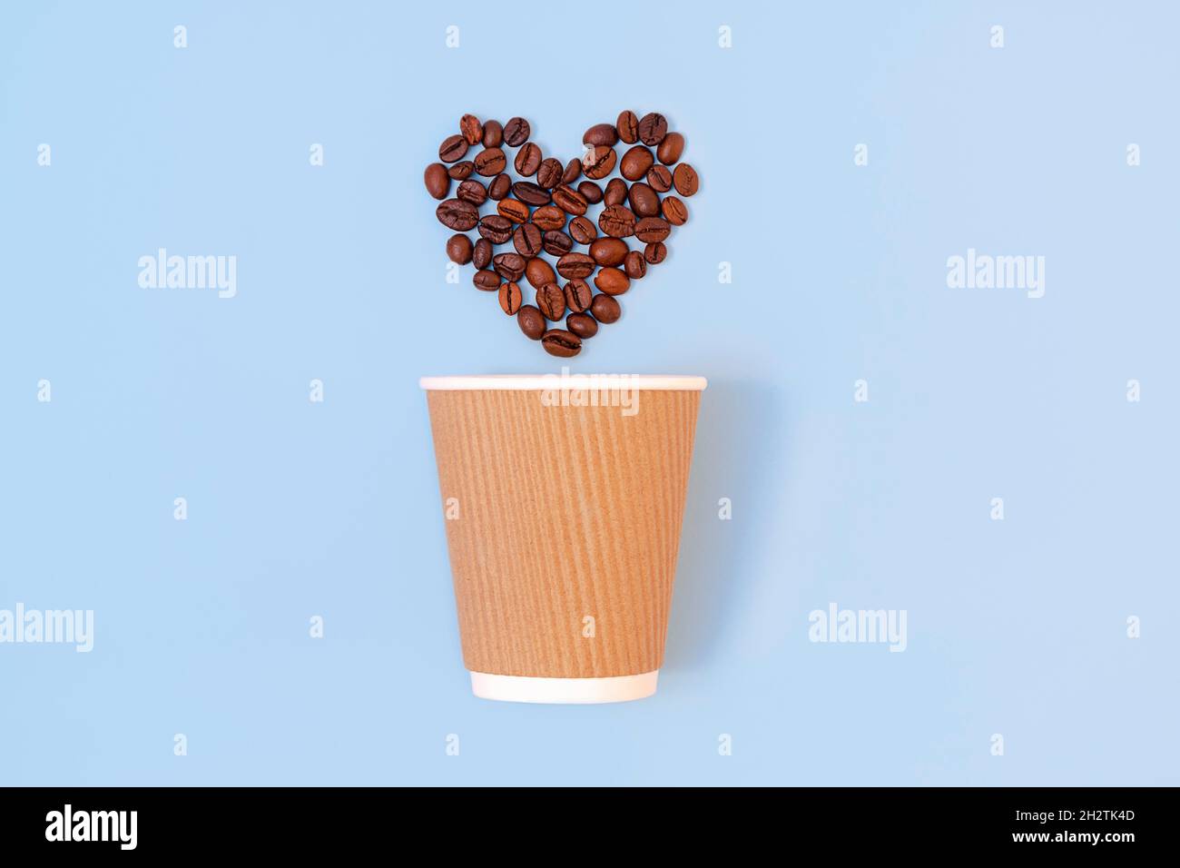 Kreative flache Lay mit Papier Einweg-Kaffeetasse und gerösteten Kaffeebohnen in Form eines Herzens auf pastellblauem Hintergrund. Umweltfreundliches und abfallfreundliches Konzept Stockfoto