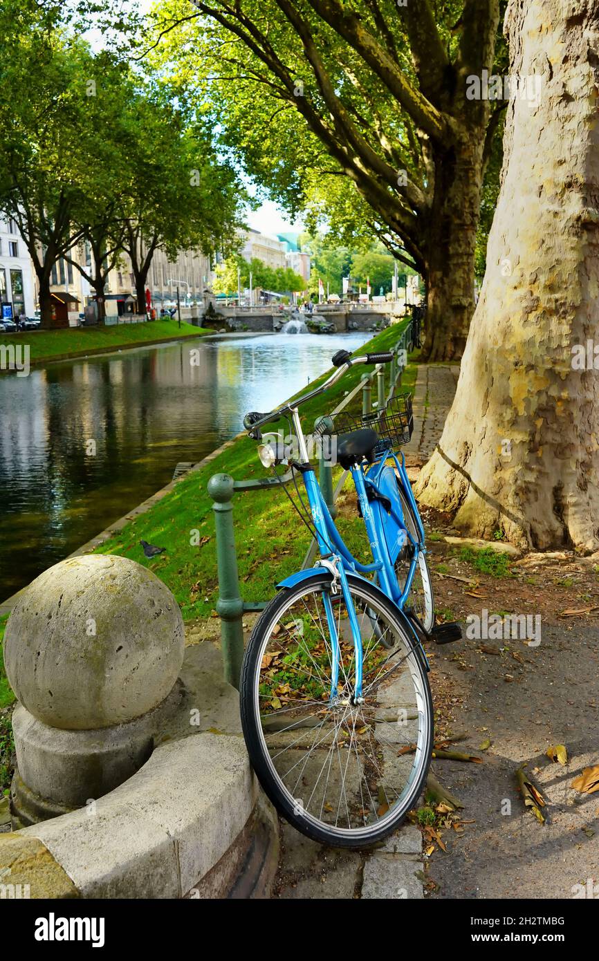 Ein geparktes Fahrrad am grünen Stadtkanal der historischen Königsallee in Düsseldorf. Stockfoto