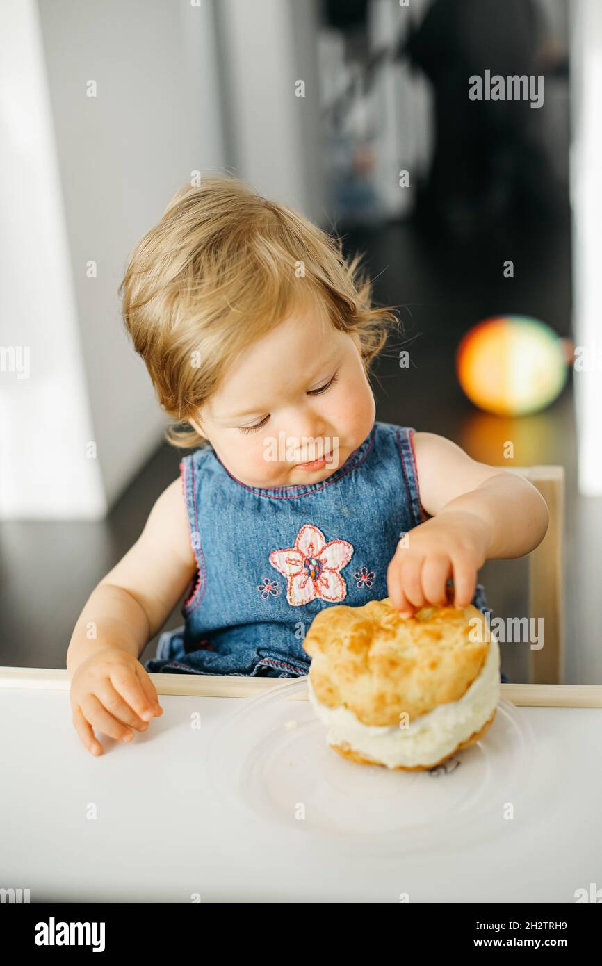 Baby hat ihren ersten Geburtstag zu Hause mit Geburtstagskuchen Stockfoto