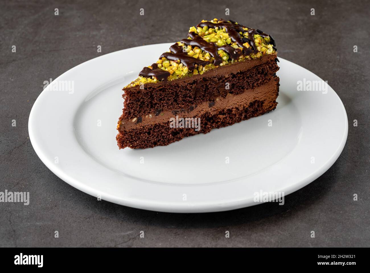 Köstliche Schokolade und Pistazien-Kuchen auf dem Tisch aus dunklem Stein Stockfoto