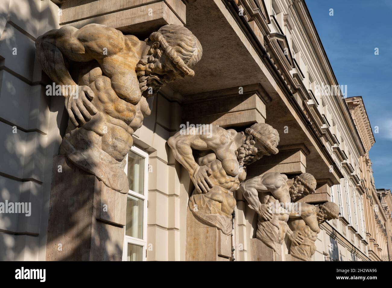 Vier atlantische Steinskulpturen, die 1787 von Andre Le Brun geschnitzt wurden, Balkonstützen im Tyszkiewicz-Palast in Warschau, Polen. Stockfoto