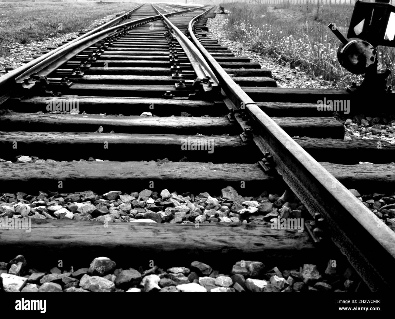 KZ Auschwitz-Birkenau, Oswiecim, Polen - dramatische Ansicht der Bahnschienen, die zu den Bahnsteigen im Lager führen. Stockfoto