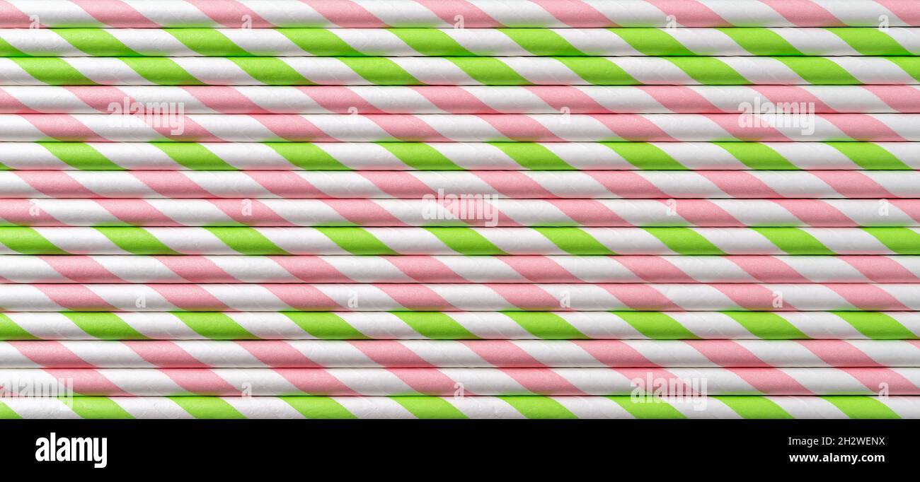 Einweg rosa grün gestreiften Cocktail Trinkhalme horizontale Textur. Makrohintergrund von papiergestreiften Trinkschläuchen. Zero Waste Konzept. Stockfoto