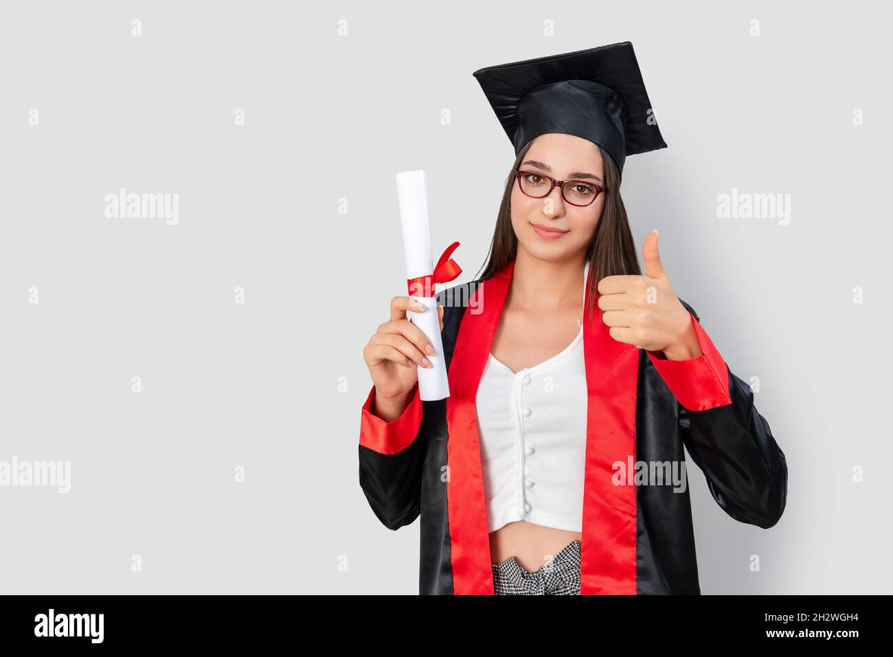 Eine hübsche rothaarige Studentin, die ihre Studienbücher hält und ihren Abschluss mit Erfolg feiert. Hochwertige Fotos Stockfoto