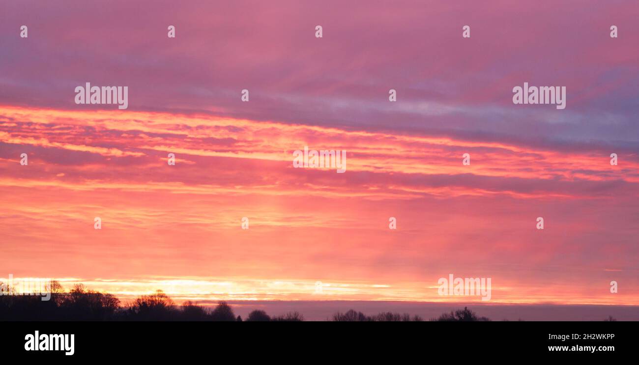 Ein mächtiger, vielfarbiger Himmel, bei dem der Sonnenaufgang scheinbar in die Zirruswolken einbricht Stockfoto