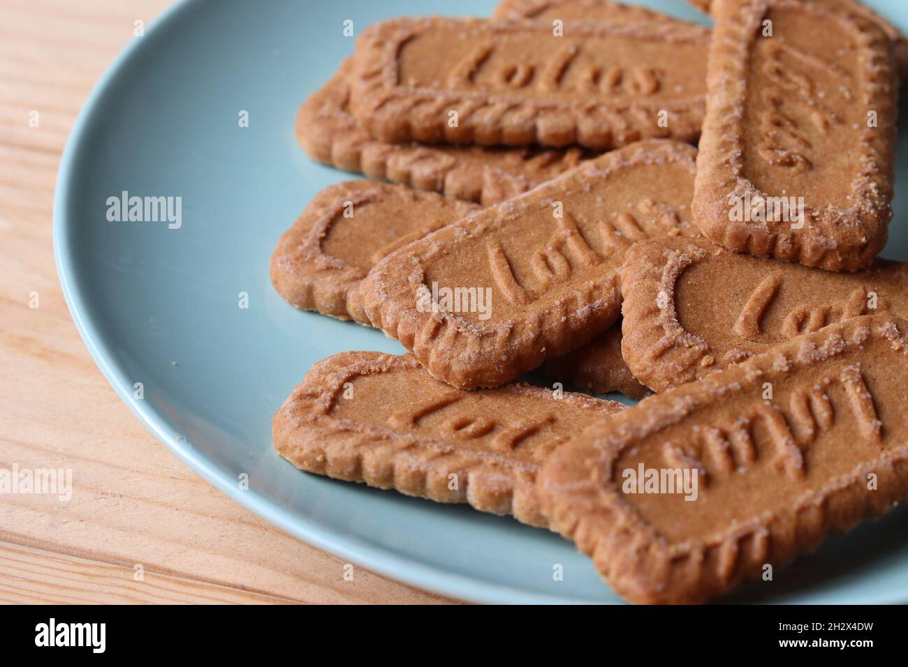 AALST, BELGIEN, 21. OKTOBER 2021: Nahaufnahme von echten belgischen Speculoos (Biscoff) Cookies auf einem Teller auf einem Holztisch. Der Keks ist jetzt ein Weltwier Stockfoto