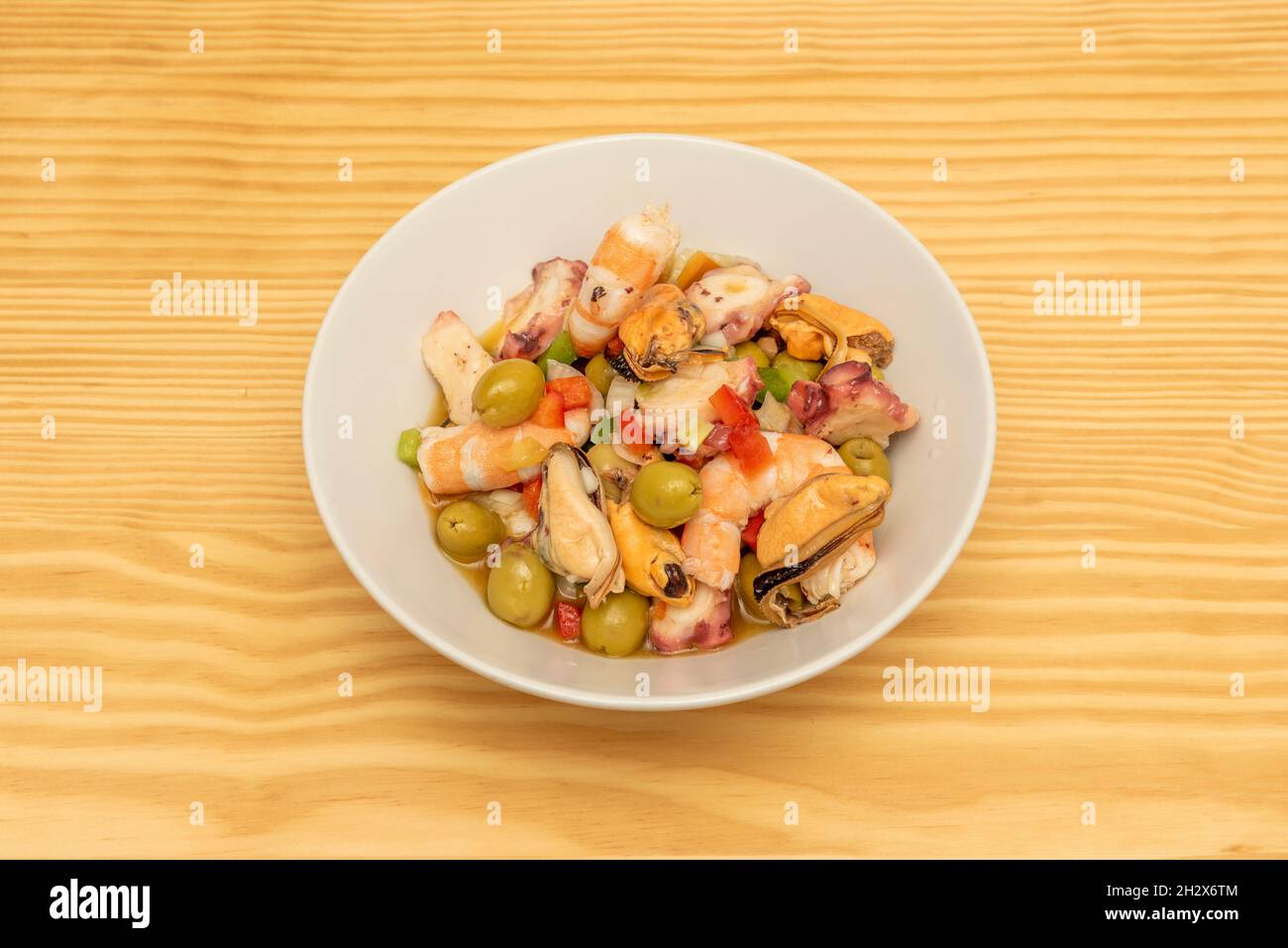 In einem spanischen Tapas-Restaurant werden Meeresfrüchte-Salpicon mit Oliven, Muschelfleisch, gekochten Garnelen, in Scheiben geschnittenem Oktopus, Zwiebeln und gehacktem Paprika serviert Stockfoto