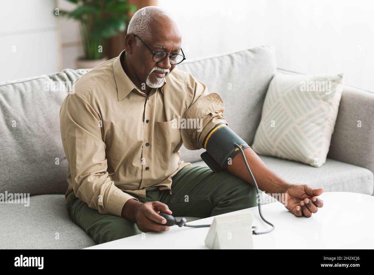Senior African Male Measuring Arterial Blutdruck Mit Hypertonie Indoor Stockfoto