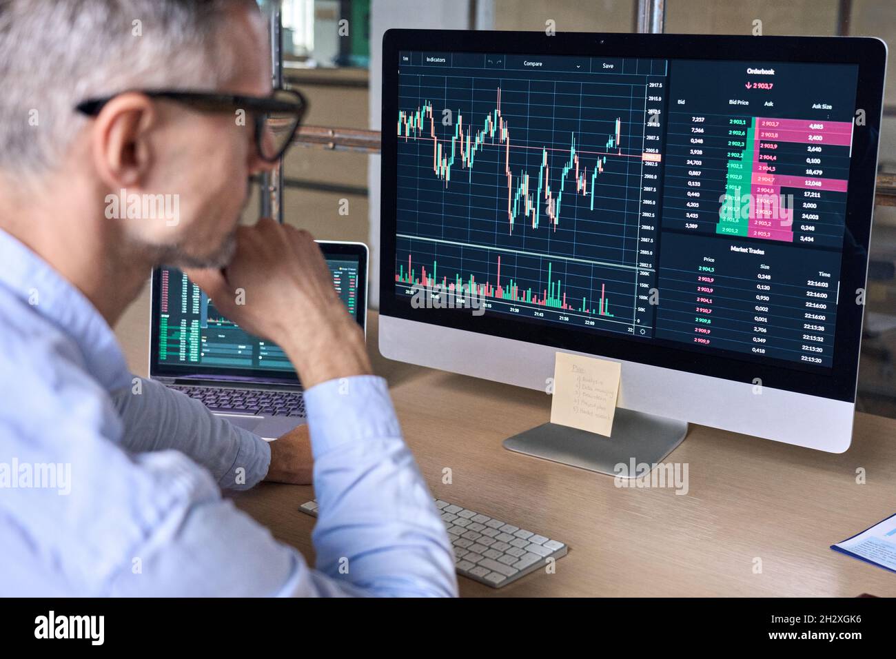 Krypto-Trader-Investor-Analyst, der sich mit der Analyse von Daten auf einem pc-Monitor am Computer ansieht. Stockfoto