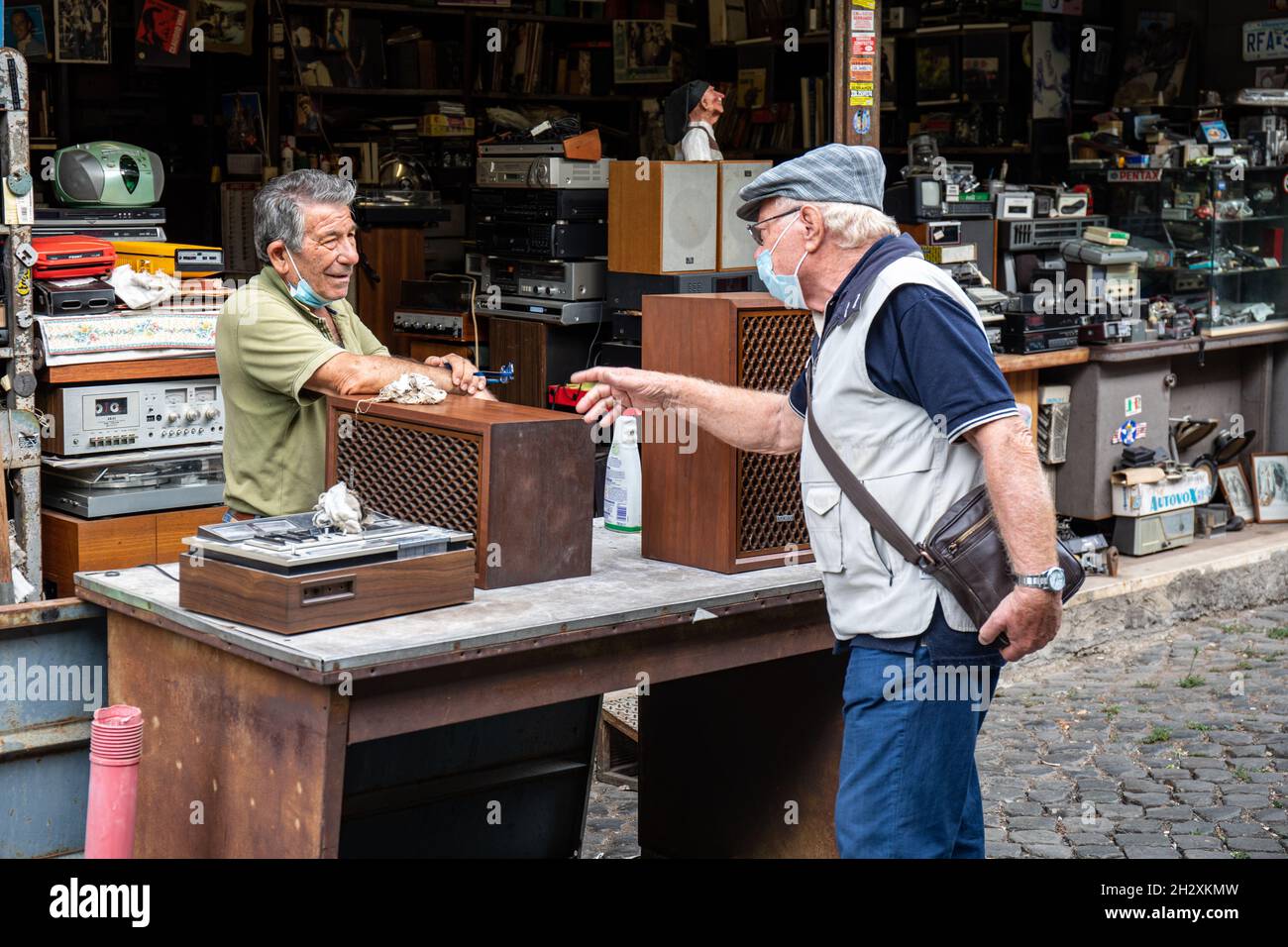 Älterer Mann, der gebrauchte AV-Geräte auf dem Clivio Portuense neben dem Mercato di Porta Portese im Stadtteil Trastevere in Rom verkauft Stockfoto