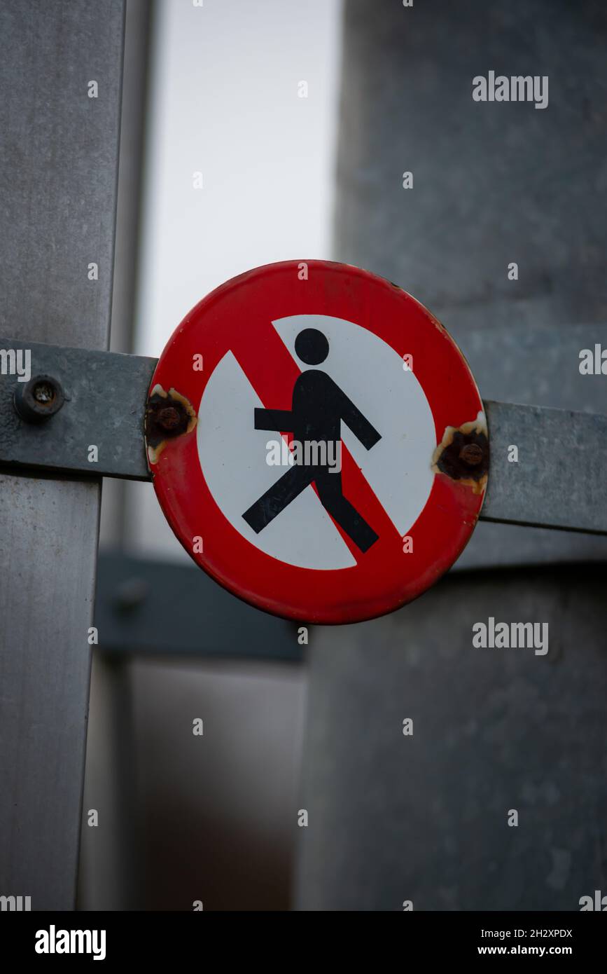 Nahaufnahme eines Schildes mit roten Menschen, die ein verbotenes Symbol auf einer Metallstruktur betreten. Stockfoto