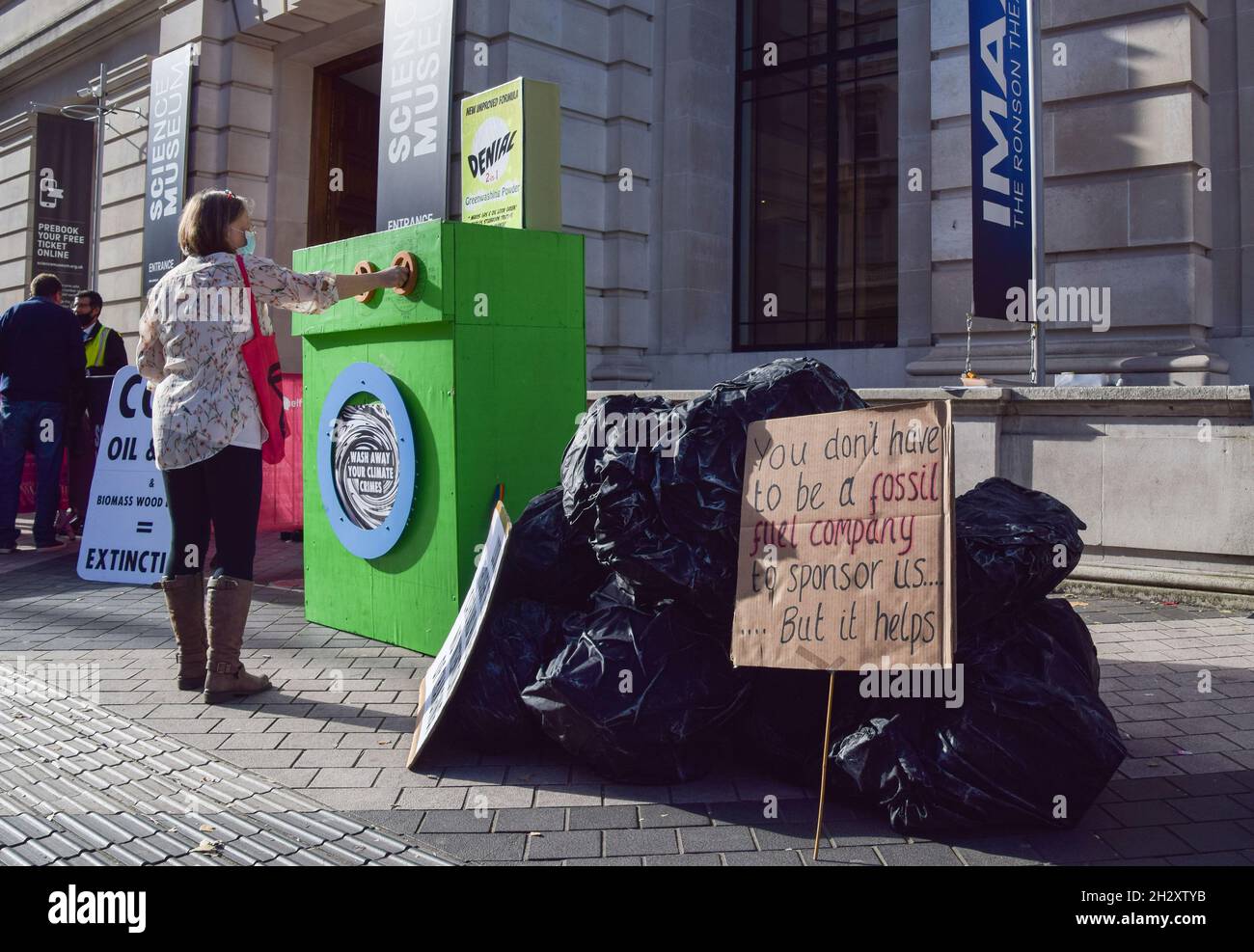London, Großbritannien. Oktober 2021. Gefälschte Kohle und eine „grüne Waschmaschine“ vor dem Wissenschaftsmuseum. Aktivisten der Extinction Rebellion versammelten sich vor dem Museum in South Kensington, um gegen die „Greenwash“-Förderung des Museums durch fossile Energieunternehmen wie Shell und den Kohleriesen Adani zu protestieren. Stockfoto