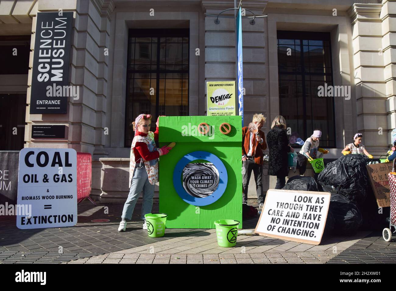 London, Großbritannien. Oktober 2021. Ein „Kruster“ reinigt die „grüne Waschmaschine“ vor dem Wissenschaftsmuseum. Aktivisten der Extinction Rebellion versammelten sich vor dem Museum in South Kensington, um gegen die „Greenwash“-Förderung des Museums durch fossile Energieunternehmen wie Shell und den Kohleriesen Adani zu protestieren. Stockfoto