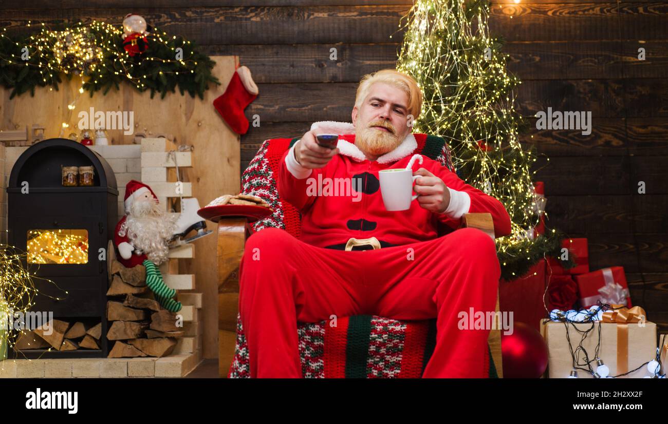 Der weihnachtsmann sitzt im Sessel und trinkt Kaffee. Frohe Weihnachten. Werbung für das neue Jahr Stockfoto