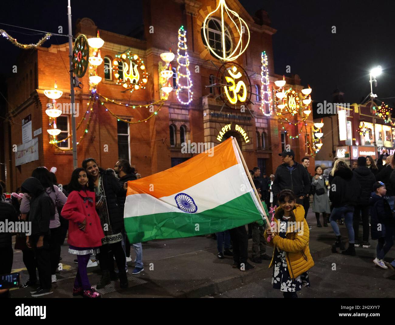 Leicester, Leicestershire, Großbritannien. Oktober 2021. Ein Mädchen schwenkt die Flagge Indiens auf der Goldenen Meile, nachdem die Diwali-Lichter eingeschaltet wurden, was sich von der normalen Veranstaltung Unterschied, da es keine Hauptbühne oder ein Feuerwerk gab, weil Covid-19 Sorgen machte. Credit Darren Staples/Alamy Live News. Stockfoto