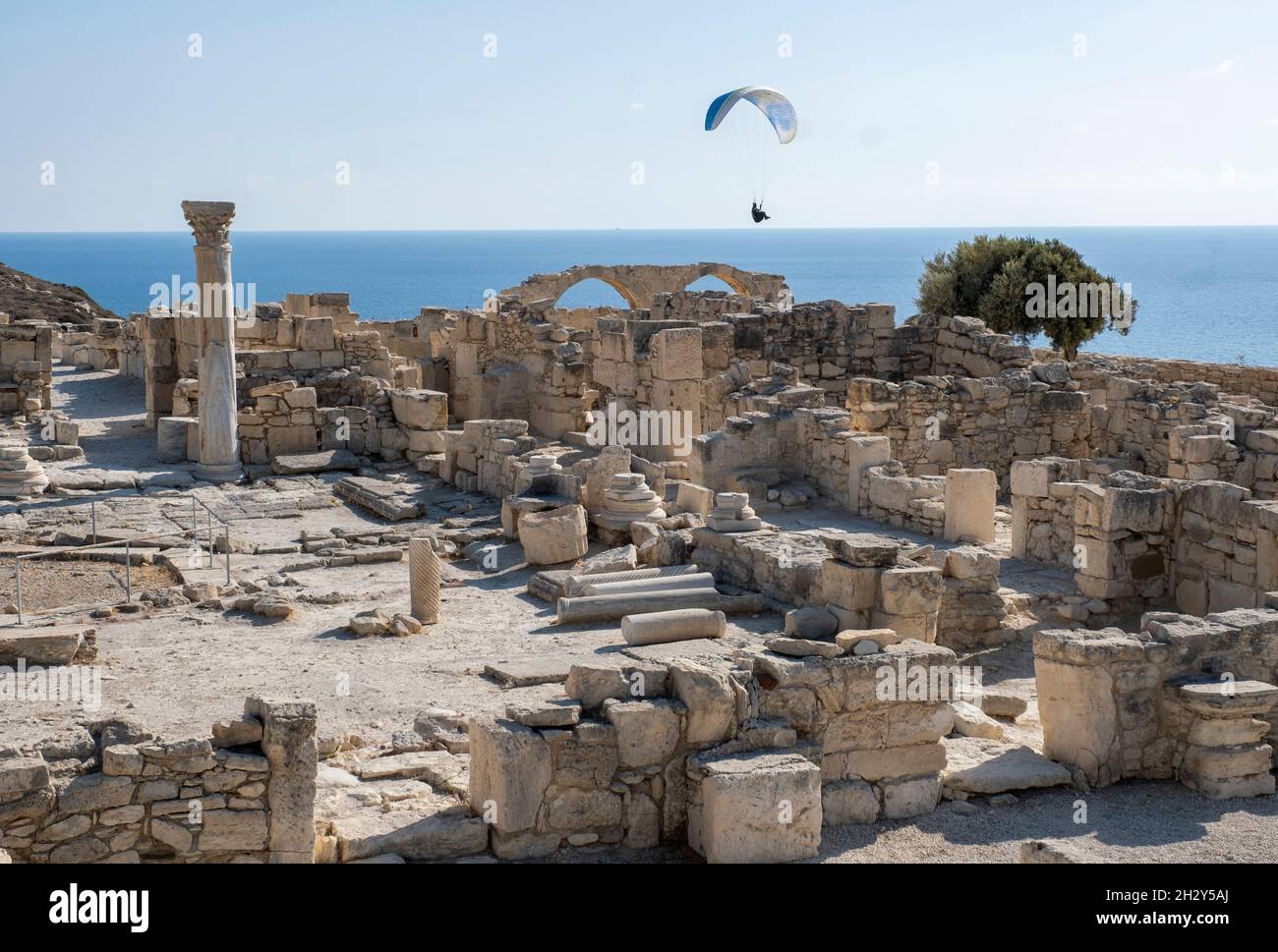 Gleitschirm gleitet über die Ruinen der frühchristlichen Basilika in der archäologischen Stätte von Kourion, Zypern. Stockfoto