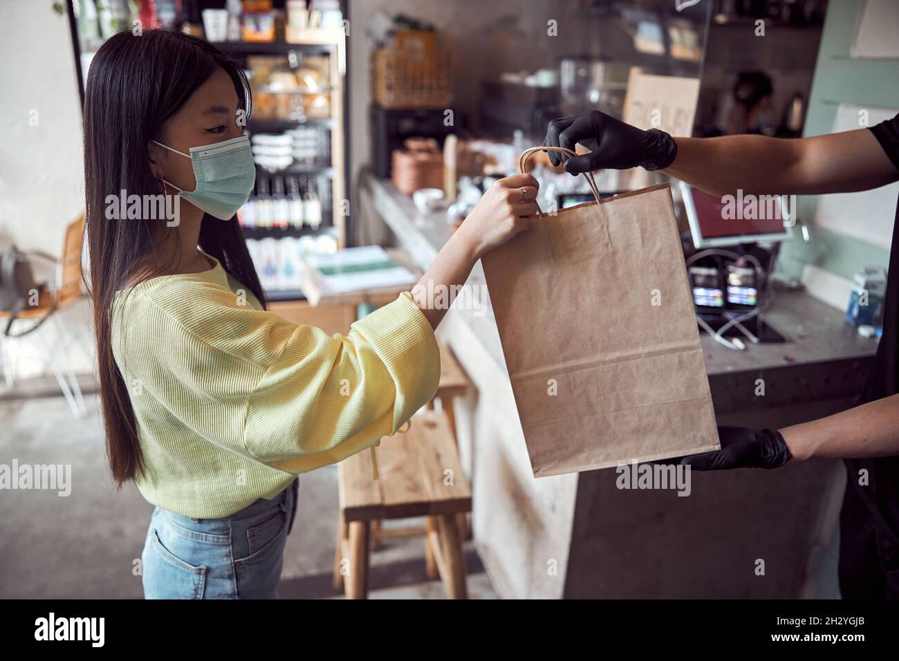 Der Kellner gab den Gästen im Café verpackte Speisen zum Mitnehmen Stockfoto