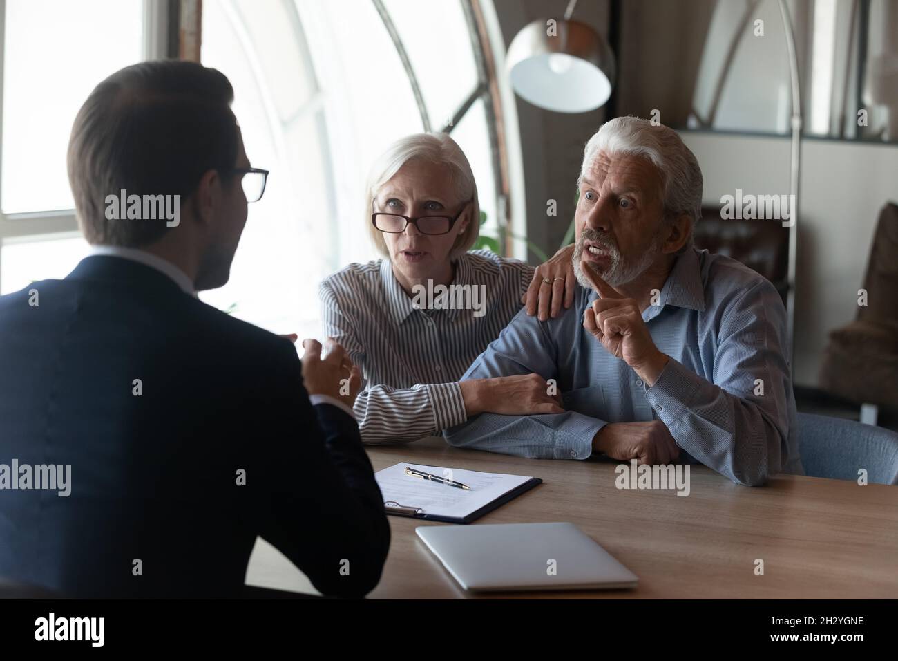 Verärgerte reife Ehepartner Betrüger klagen Anwalt über kommerziellen Betrug Stockfoto