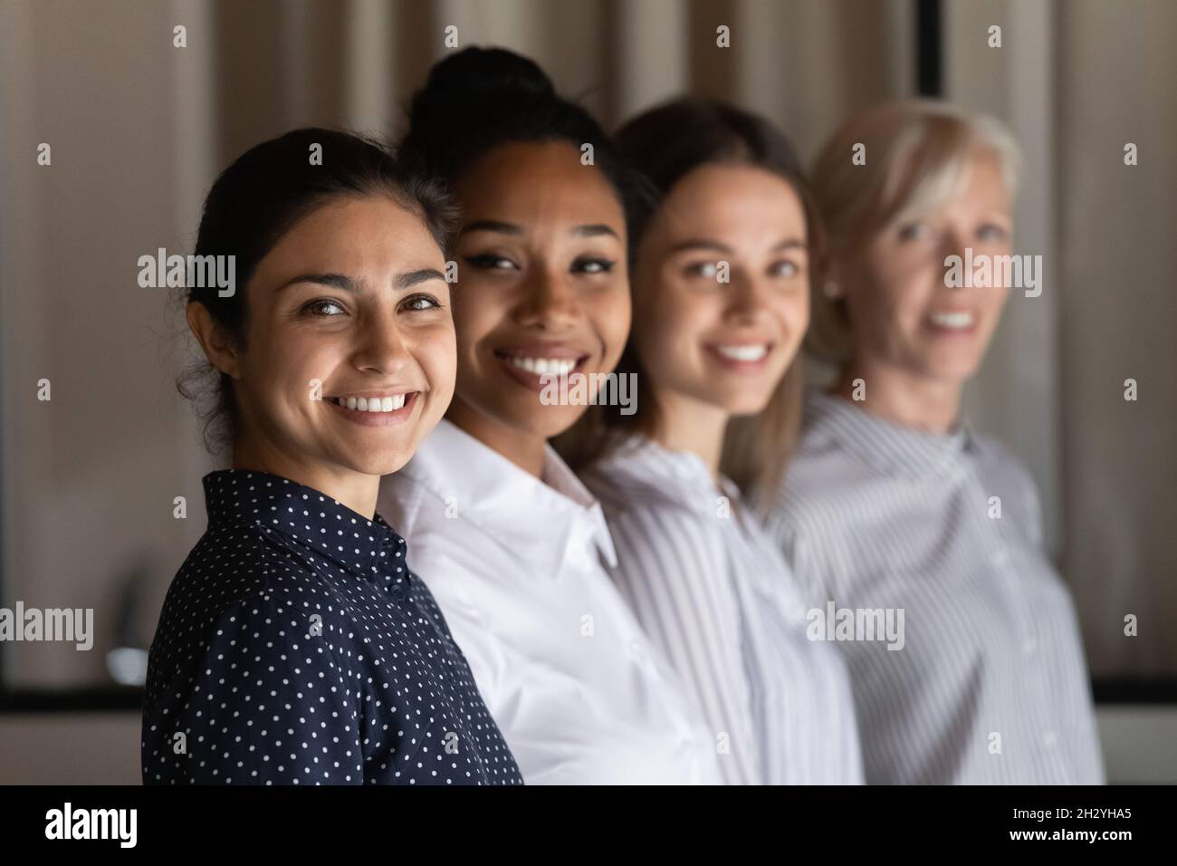 Eine multiethnische Gruppe von selbstbewussten Büroangestellte Frauen steht in Reihe Stockfoto