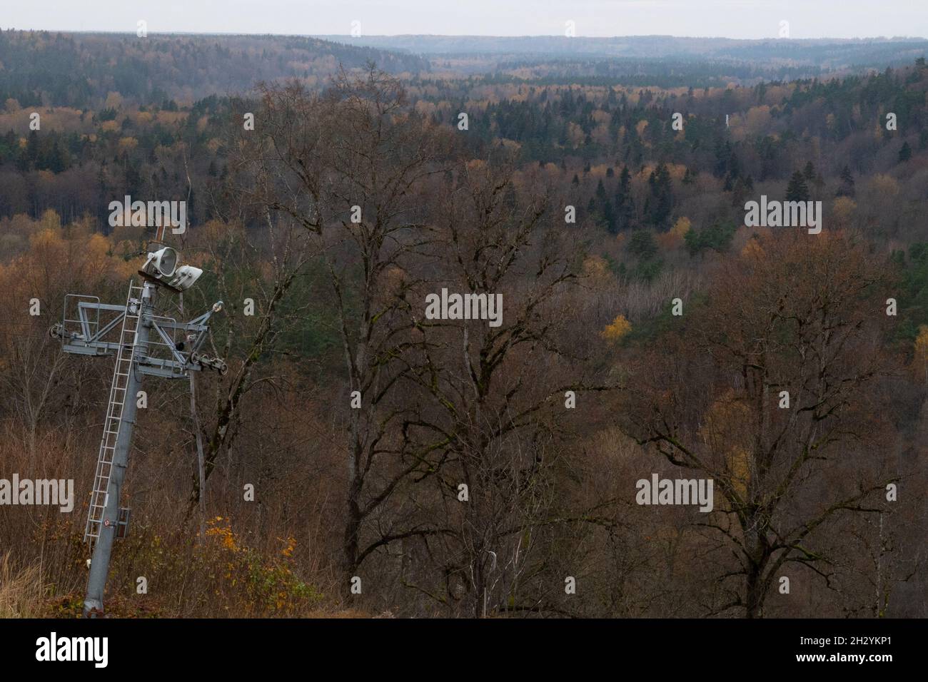 Blick auf das Waldtal im Herbst, mit einem alten Lift auf der Spitze des Hügels. Stockfoto