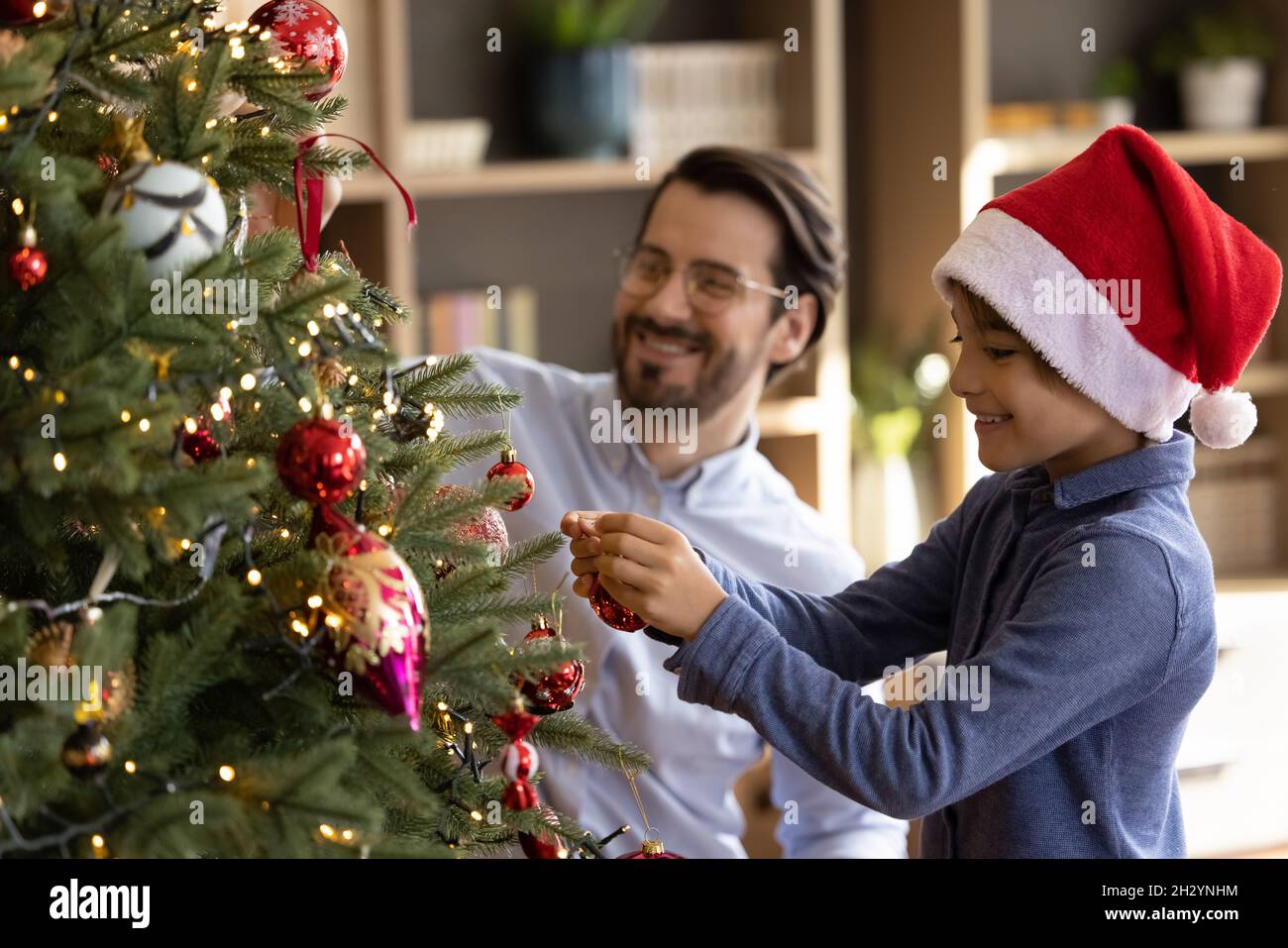 Fröhlich niedlichen kleinen Jungen Dekoration Weihnachtsbaum mit Vater. Stockfoto