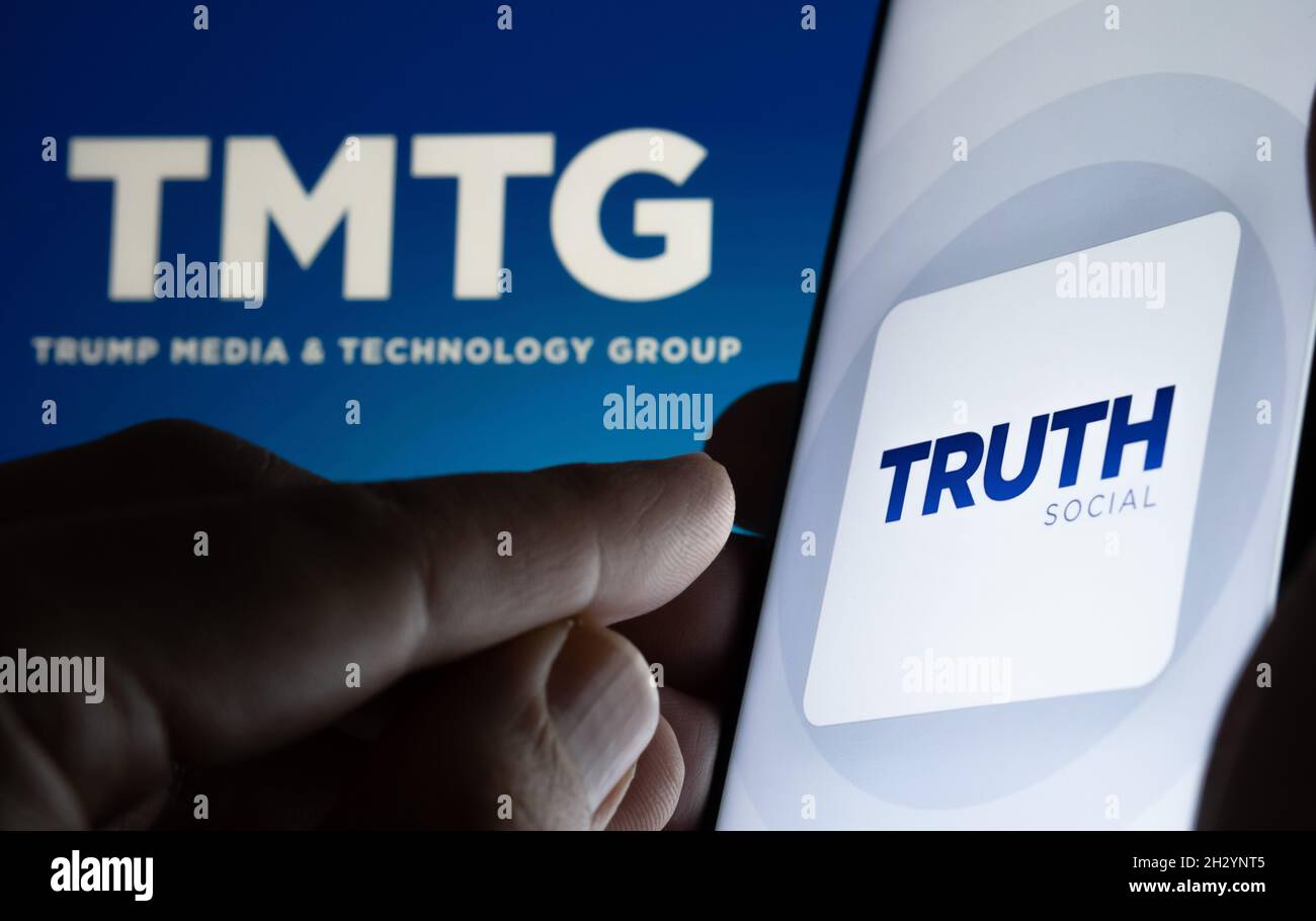 Truth Social App-Logo auf dem Smartphone und verschwommenes TMTG-Logo auf dem Laptop. Neue Social-Media-Plattform von Donald Trump. Stafford, Großbritannien Stockfoto