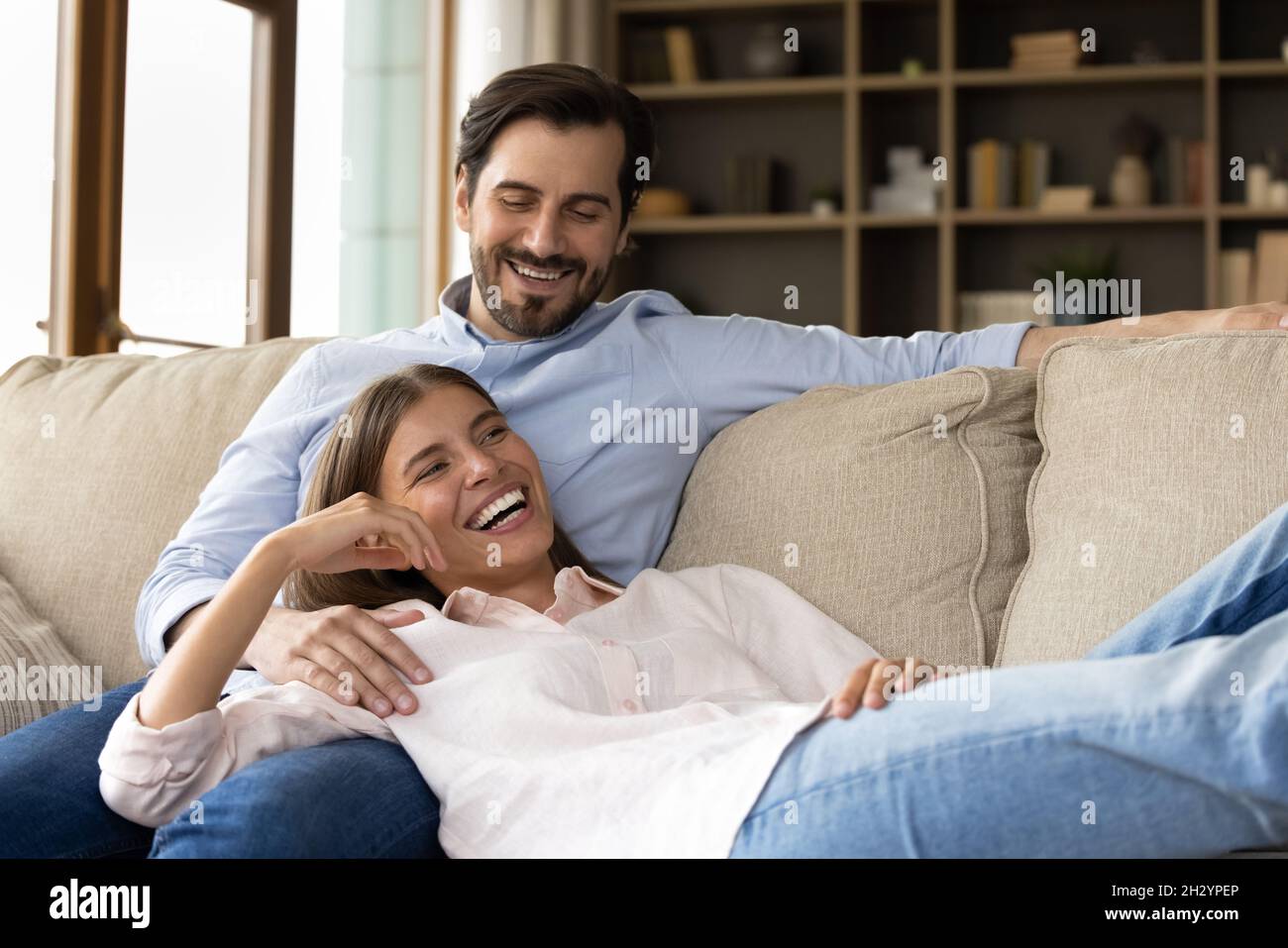 Glückliches junges Paar, das sich auf dem gemütlichen Sofa entspannt. Stockfoto