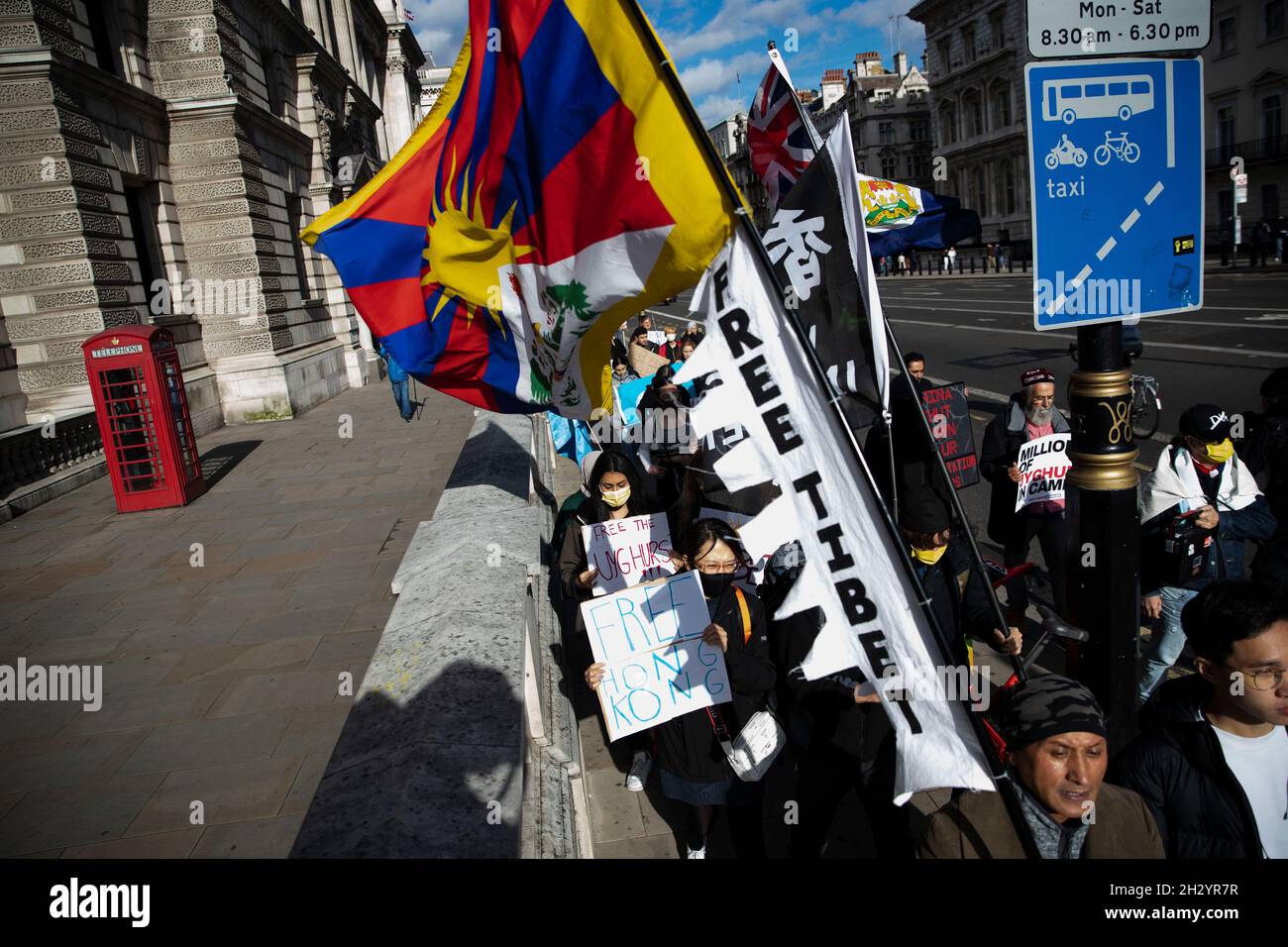 London, Großbritannien. Okt. 2021. Die Demonstranten halten während der Demonstration Fahnen und Plakate, auf denen ihre Meinung zum Ausdruck kommt.Eine Kundgebung, die von sechs verschiedenen Menschenrechtsgruppen aus Uiguren, Tibet und Hongkong organisiert wurde und zu „Sagen Sie Nein zu den Olympischen Winterspielen in Peking, sagen Sie Nein zum Völkermord“ aufrief, die mit drei Kernaufgaben verbunden war: „Protest gegen die Olympischen Winterspiele 2022 in Peking“, „Unterstützung der Uiguren, Tibeter und der Menschen in Hongkong“ und „eine Fackelstaffel zur Interpretation des olympischen Geistes“. (Foto von May James/SOPA Images/Sipa USA) Quelle: SIPA USA/Alamy Live News Stockfoto