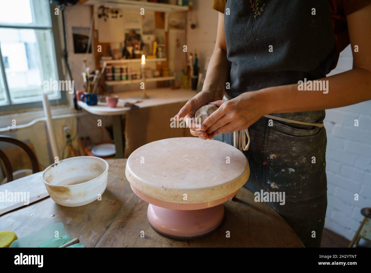 Töpferei Künstlerin weibliche Form Ton auf Rad. Keramiker in Schürze arbeiten mit rohem Steingut für Töpfer Stockfoto