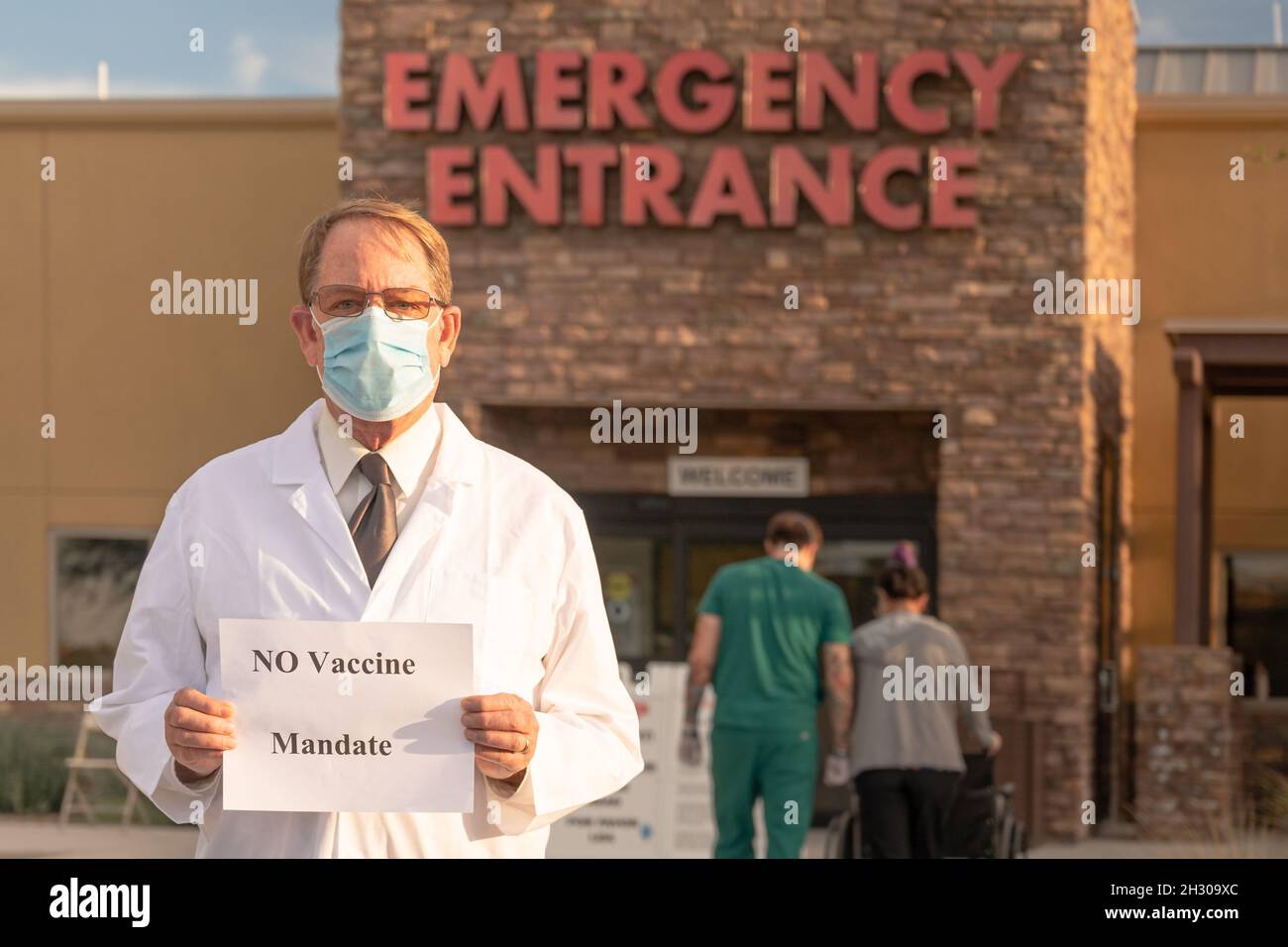 ER-Arzt hält vor dem Eingang des Krankenhauses ein Zeichen ohne Impfauftrag Stockfoto