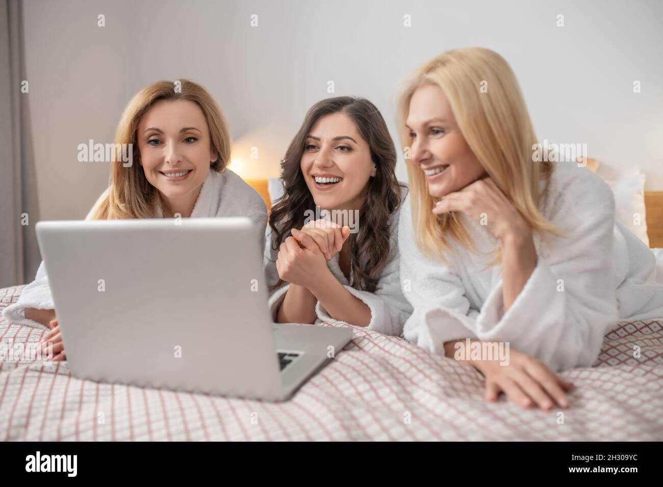Frauen mittleren Alters, die auf einem Laptop liegen Stockfoto