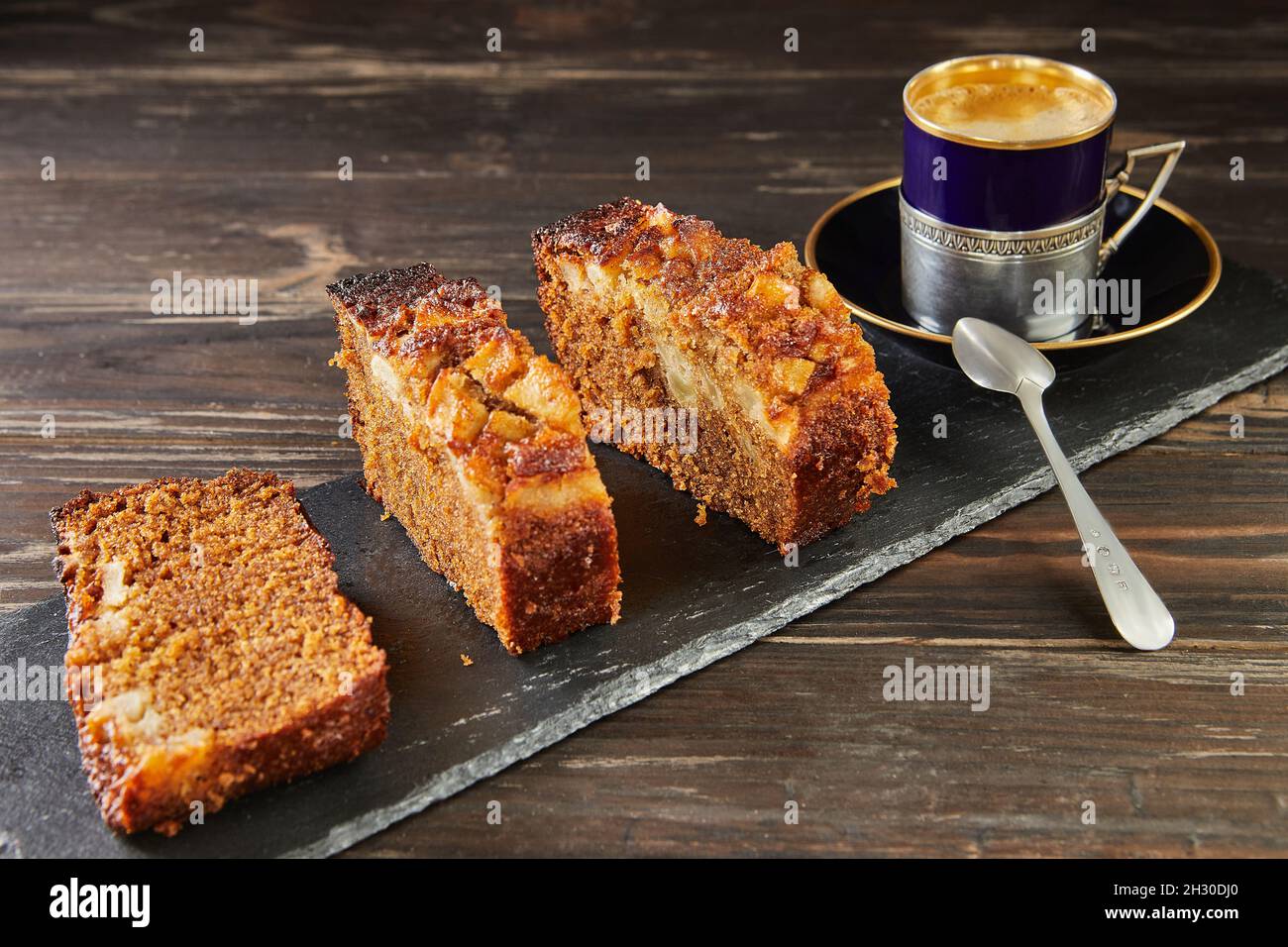 Honigkuchen mit Äpfeln und einer Tasse Kaffee in der Nähe. Französische Gourmetküche Stockfoto