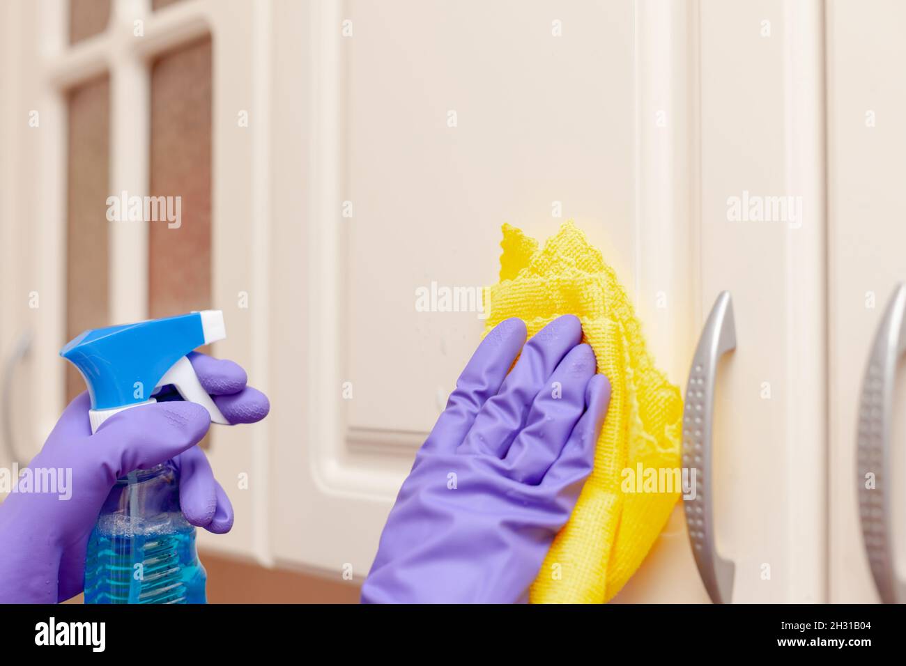 Die Hand einer Frau wischt die Küchentür aus nächster Nähe ab Stockfoto