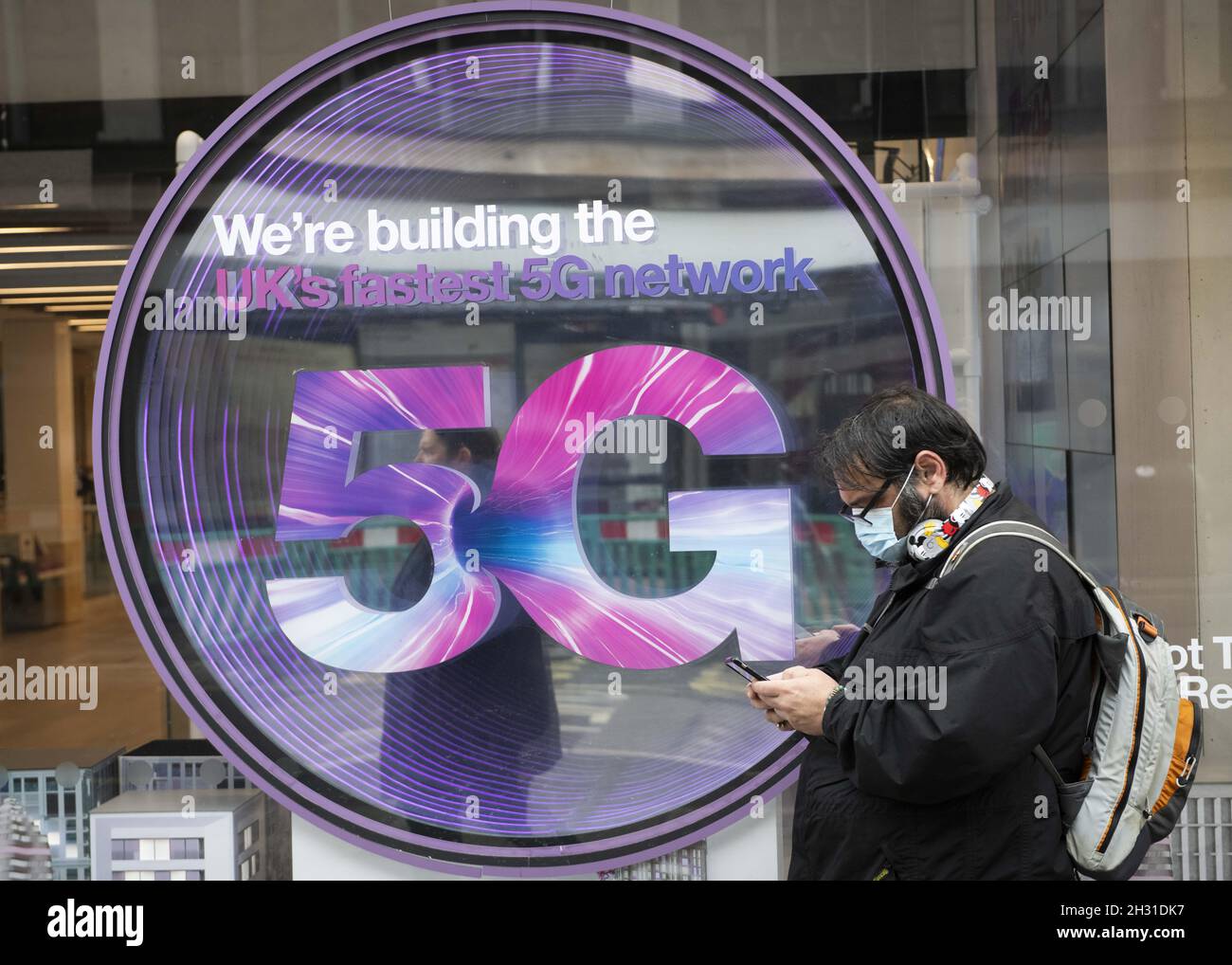 Ein Mitglied der Öffentlichkeit überprüft sein Telefon vor einem Mobilfunkgeschäft mit einem 5G-Schild, Oxford Street, London. Bilddatum: Freitag 12. Juni 2020. Bildnachweis sollte lauten: David Jensen/EMPICS Entertainment Stockfoto