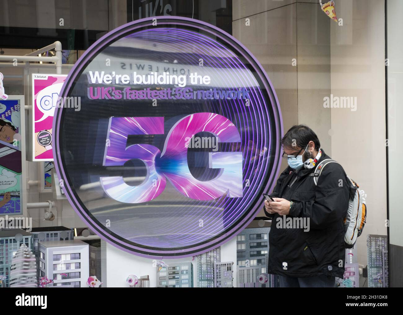 Ein Mitglied der Öffentlichkeit überprüft sein Telefon vor einem Mobilfunkgeschäft mit einem 5G-Schild, Oxford Street, London. Bilddatum: Freitag 12. Juni 2020. Bildnachweis sollte lauten: David Jensen/EMPICS Entertainment Stockfoto