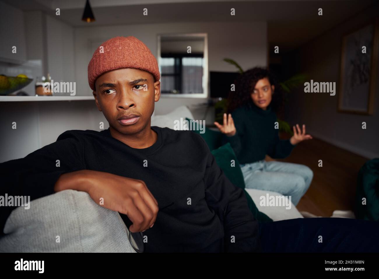Erwachsene multi-ethnischen Paar kämpfen, während auf dem Sofa in der modernen Wohnung Stockfoto