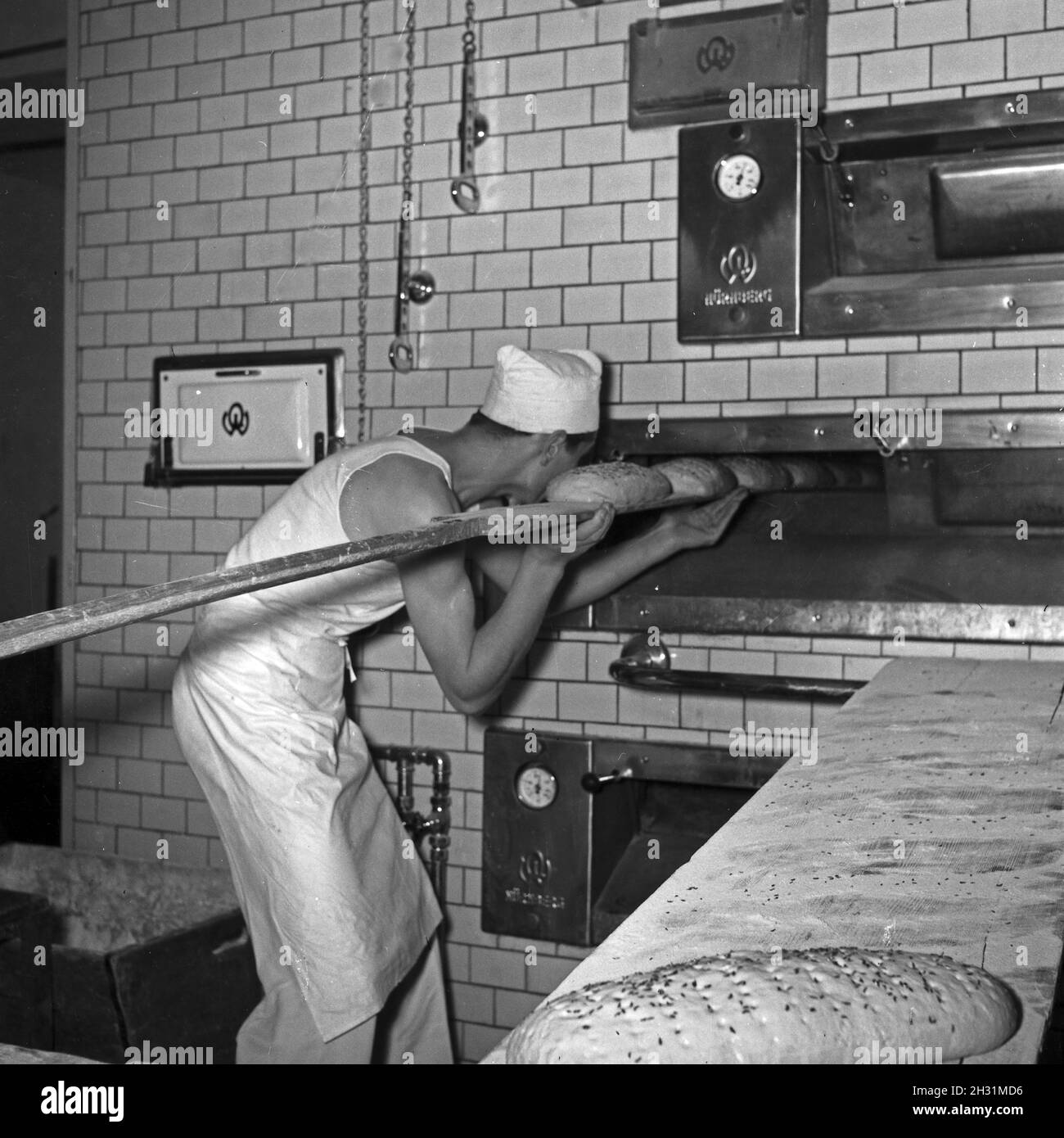 Ein Bäcker bei seiner täglichen Arbeit, Deutschland 1950er Jahre. Ein Bakerman und sein Tagesgeschäft, Deutschland der 1950er Jahre. Stockfoto