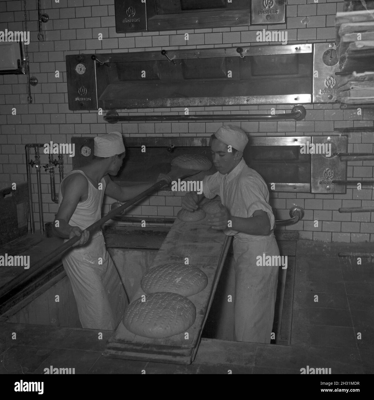 Ein Bäcker bei seiner täglichen Arbeit, Deutschland 1950er Jahre. Ein Bakerman und sein Tagesgeschäft, Deutschland der 1950er Jahre. Stockfoto