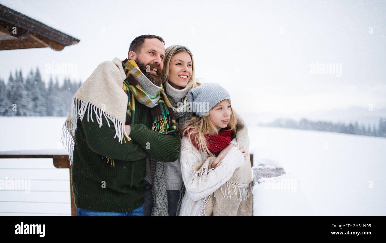 Familie mit kleiner Tochter auf Terrasse im Freien, Urlaub im Winter Natur. Stockfoto