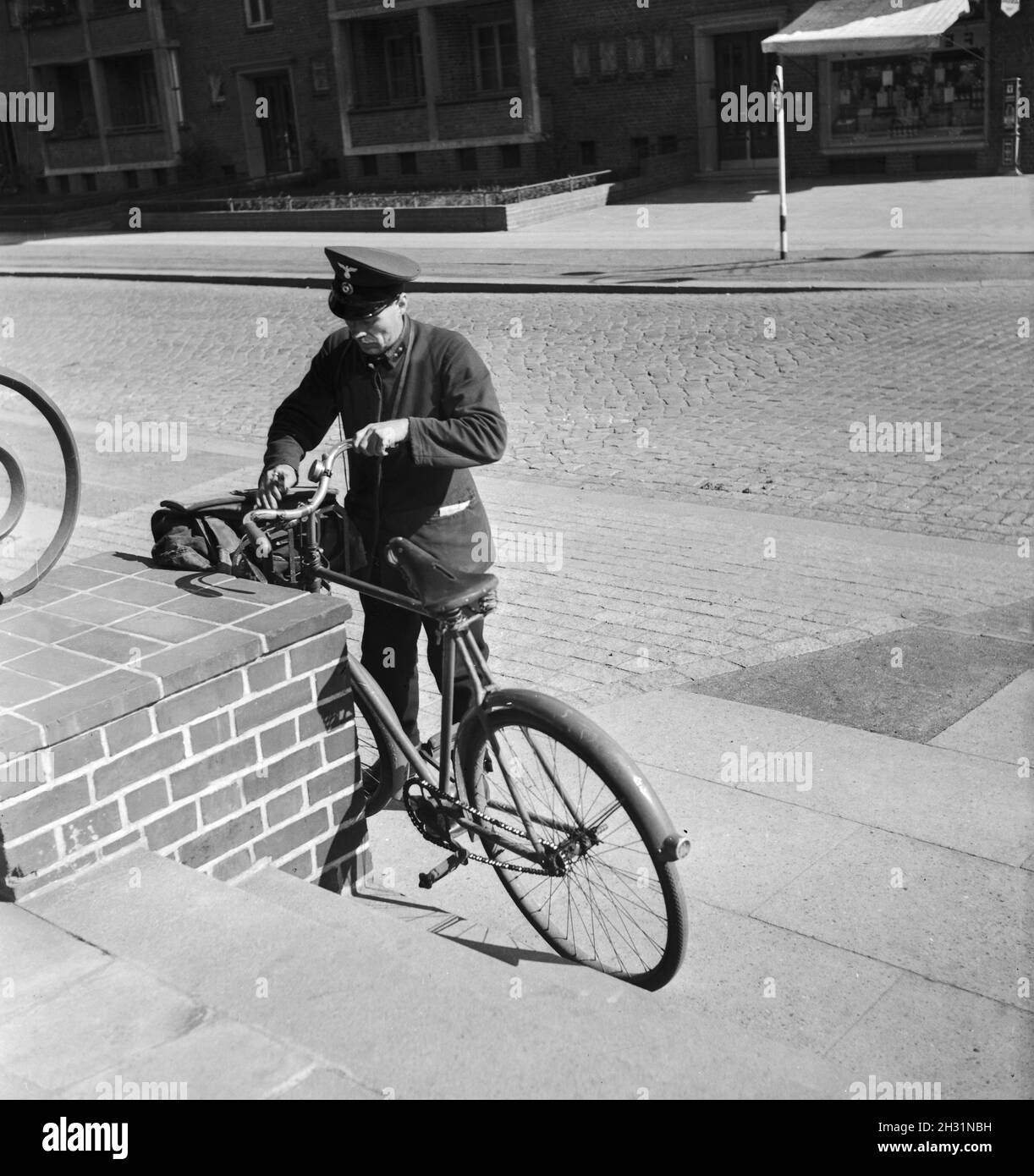 Polizeibeamter in der Fehnkolonie Woprswede mit Fahrrad, Deutsches Reich 1930er. Polizeibeamter in Fehnkolonie Woprswede mit Fahrrad, Deutsches Reich 1930er Jahre. Stockfoto