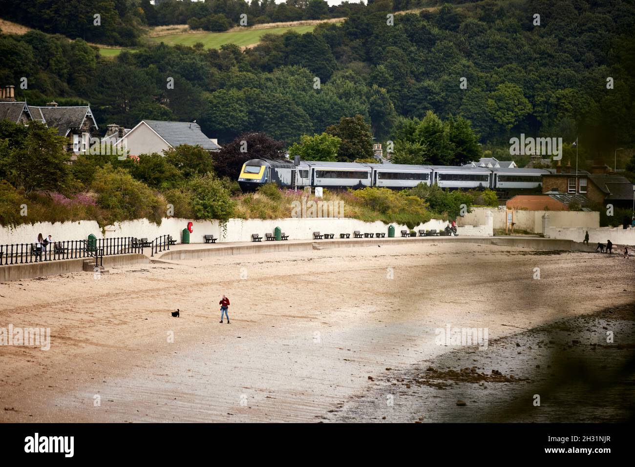 Burntisland, Fife, Schottland, der Strand an der Mündung des Firth of Forth mit einem Scotrail HST-Zug, der vorbeifährt Stockfoto
