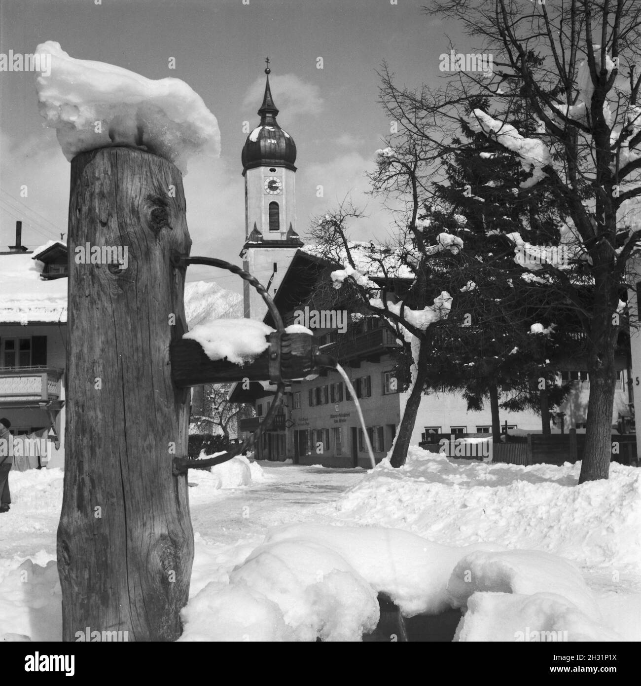 Blick in einen Ortskern mit Kirche und Ladenlokalen, Deutschland 1930er Jahre. Blick auf die Stadt Zentrum mit Glockenturm und eine Apotheke, Deutschland 1930. Stockfoto