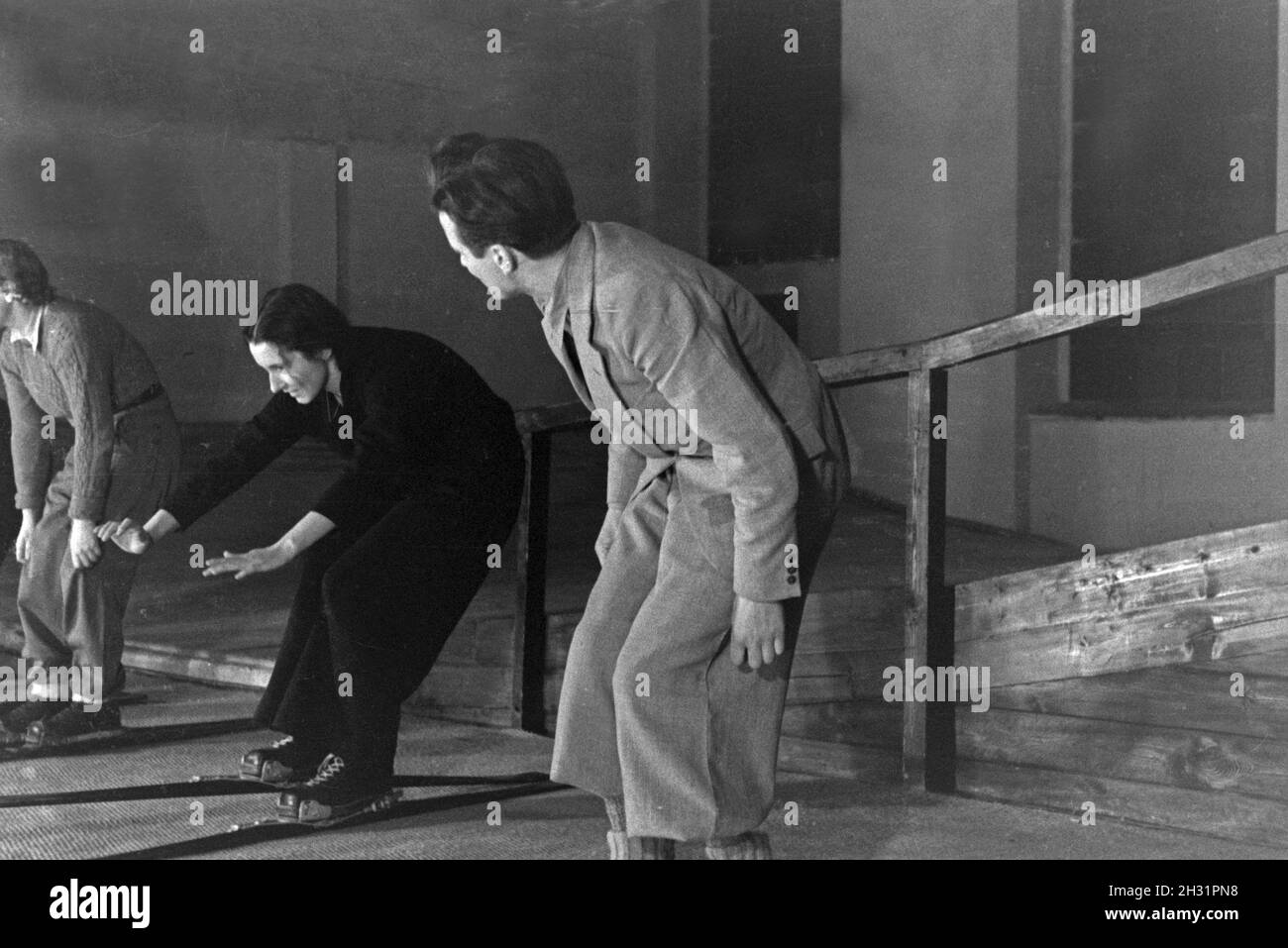 Ein Skilehrer beim Fremdsprachenunterricht mit Ski Anfängerinnen in einer Skihalle, Deutschland 1930er Jahre. Ein Ski Lehrer an einer Lektion mit femals Skianfänger, Deutschland 1930. Stockfoto