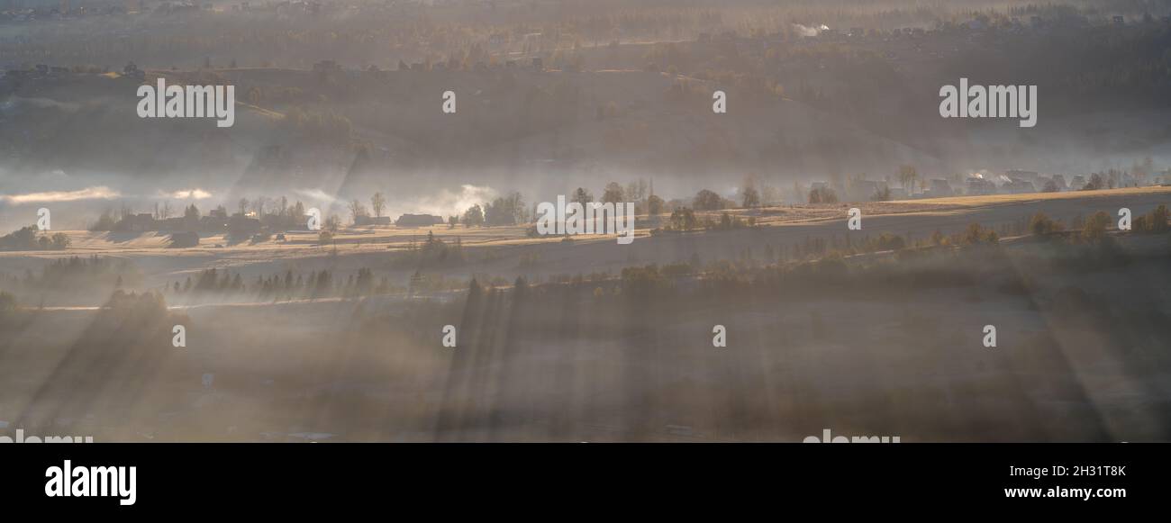 Bergdorf in Mitteleuropa am Morgen Rauch und Smog aus holzbefeuerten Öfen und Kohle Stockfoto