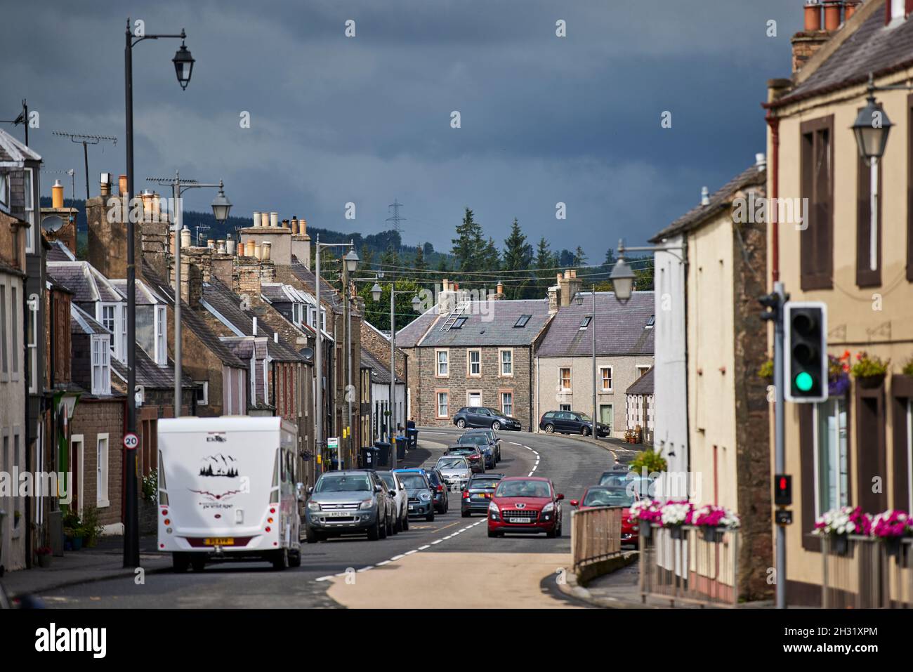 Lauder, in den schottischen Boarders Scotland, dachte A68 High Street, dass das Dorf auf eine Geschwindigkeitsbegrenzung von 20 km/h eingestellt war, das rote Auto geht langsam, Stockfoto