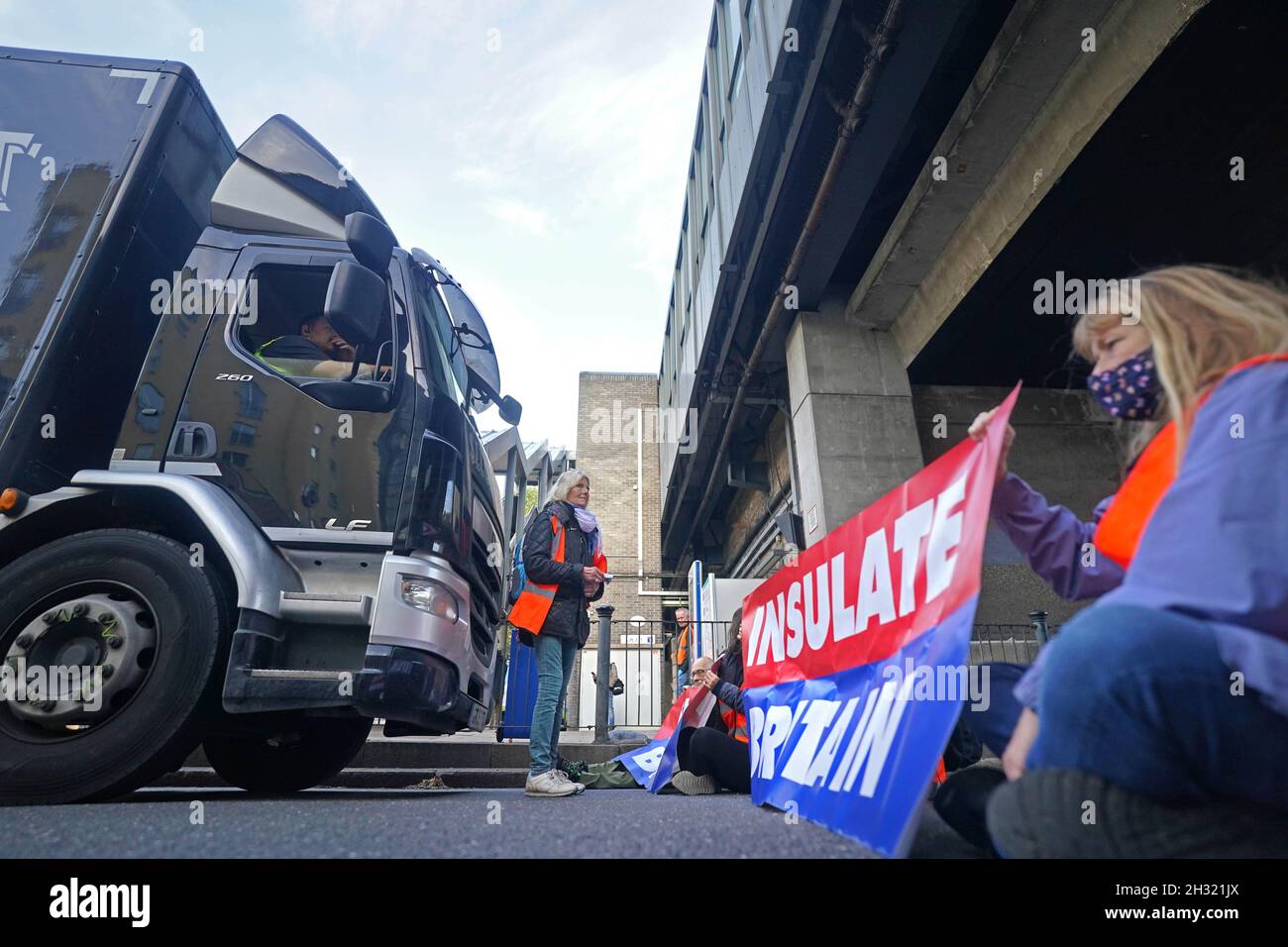 Demonstranten, die Großbritannien davon abbringen, eine Straße in der Nähe von Canary Wharf im Osten Londons zu blockieren. Die Klimagruppe, die Großbritannien beleidigt hatte, hatte versprochen, ihre Blockaden-Proteste wieder aufzunehmen, obwohl die Gefahr besteht, dass seine Mitglieder inhaftiert oder mit Geldstrafen belegt werden. Bilddatum: Montag, 25. Oktober 2021. Stockfoto