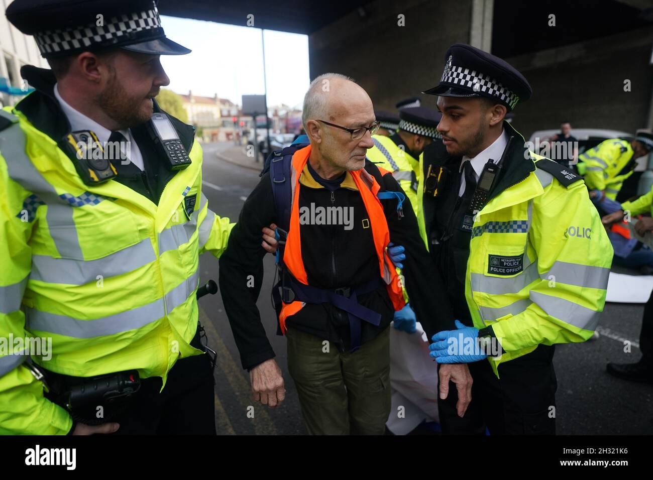Die Polizei beseitigt die Beleidigung britischer Demonstranten, nachdem sie eine Straße in der Nähe von Canary Wharf im Osten Londons blockiert hatten. Die Klimagruppe, die Großbritannien beleidigt hatte, hatte versprochen, ihre Blockaden-Proteste wieder aufzunehmen, obwohl die Gefahr besteht, dass seine Mitglieder inhaftiert oder mit Geldstrafen belegt werden. Bilddatum: Montag, 25. Oktober 2021. Stockfoto