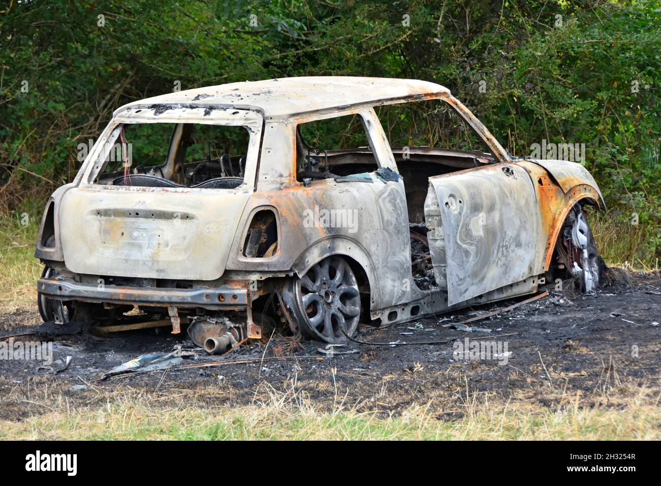 Gestohlenes BMW Mini-Auto in Fackelbrennerei und Ausbrennen in abgelegener ländlicher Landwirtschaft auf verbrannter Erde in Essex England, Großbritannien, zerstört und abgeladen Stockfoto