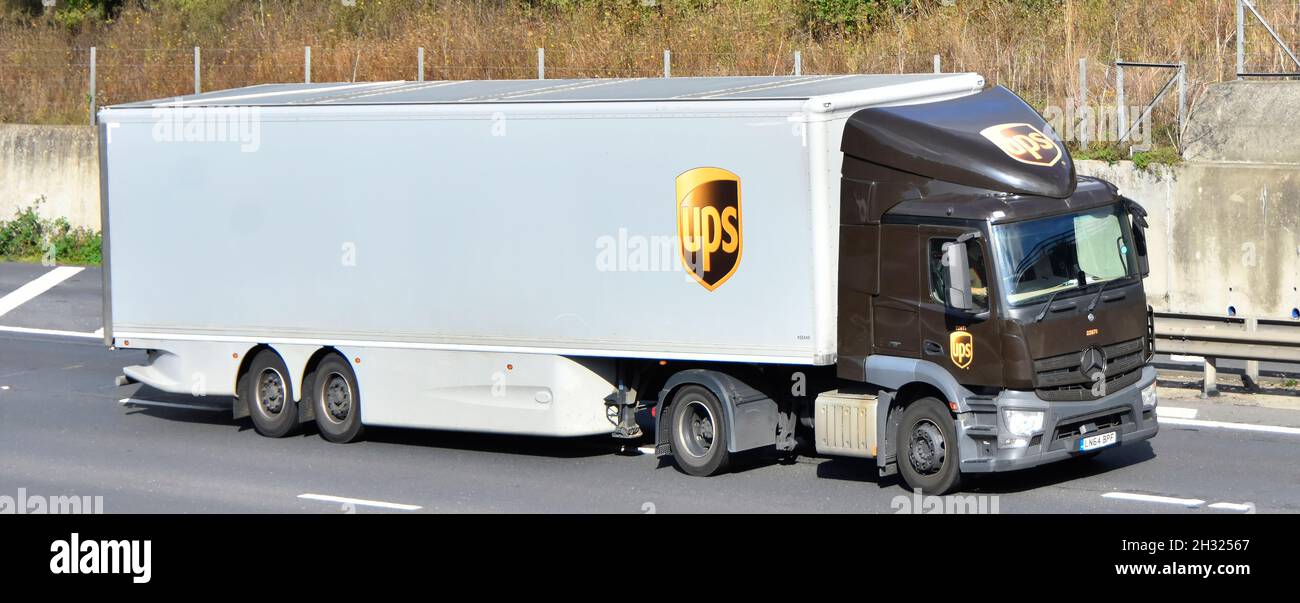 Seiten- & Vorderansicht Lieferkettenlieferungen für LKW von United Parcel Service UPS pakt ein Markenlogo auf lkw-Sattelanhänger English motorway UK Stockfoto