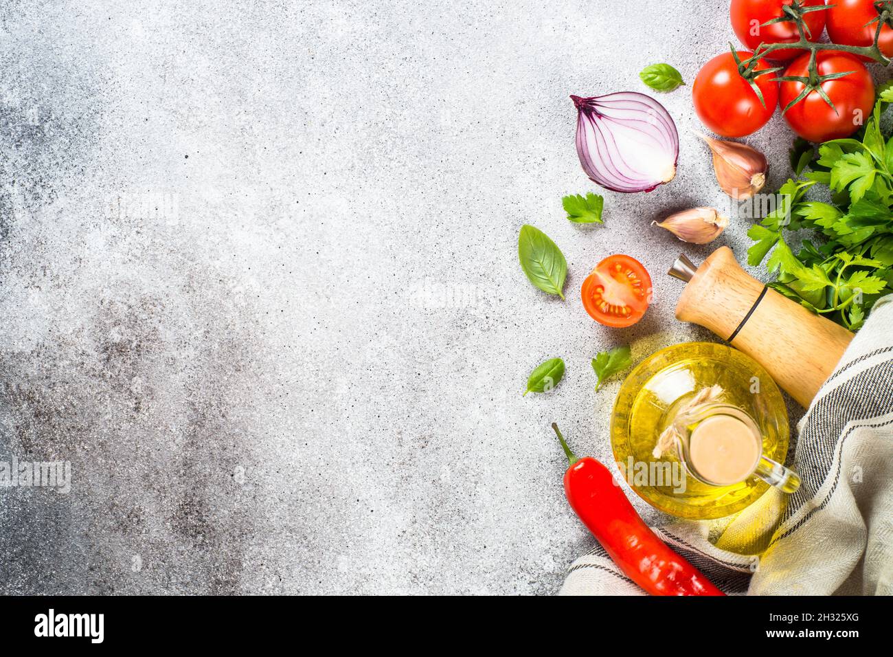 Olivenöl, Kräuter und Gemüse am Steintisch von oben. Stockfoto